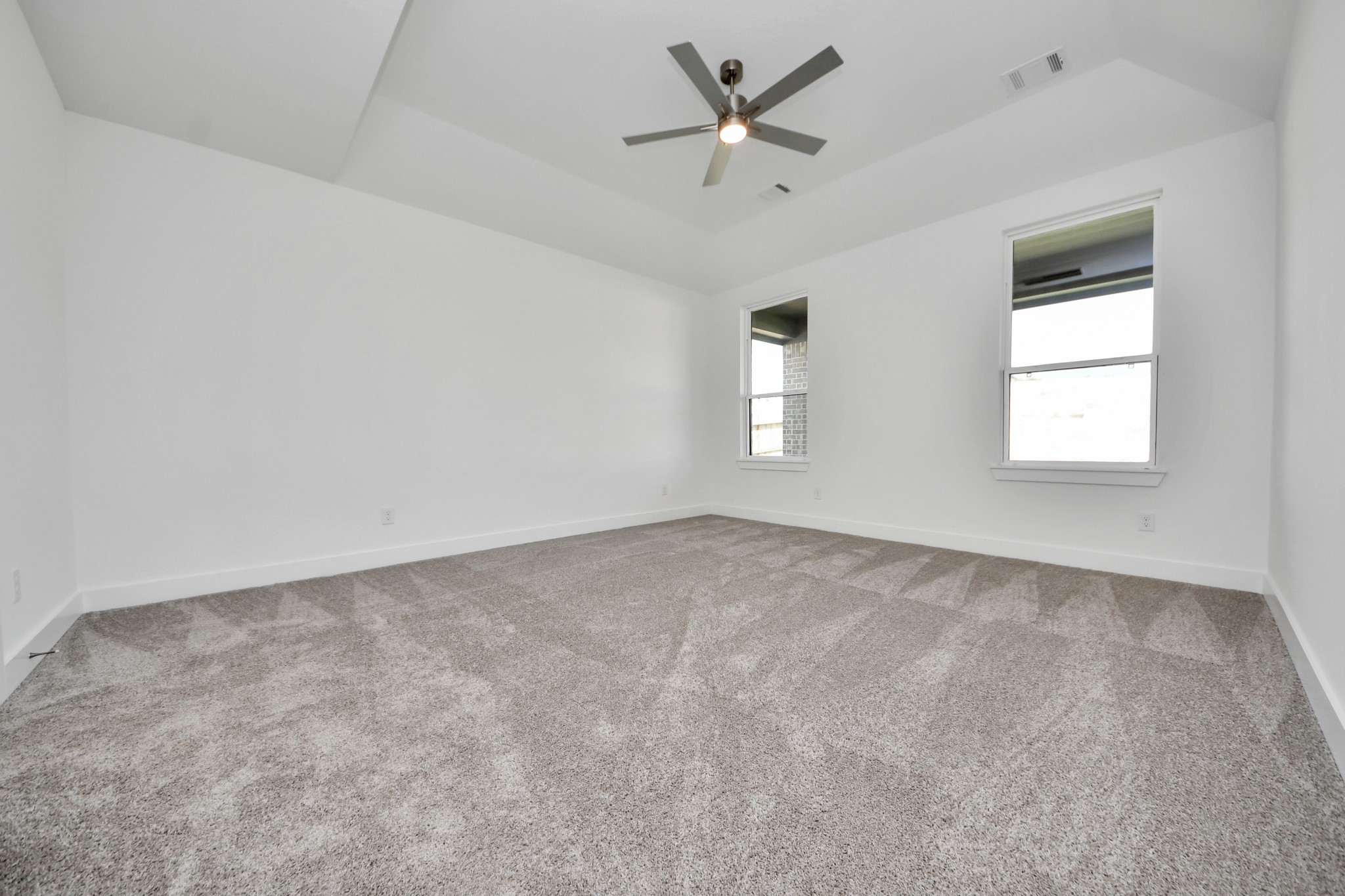 Retreat to the luxurious primary suite, your perfect escape for unwinding after a long day. Located on the first floor, this spacious room features plush carpeting, calming paint tones, high ceilings, and large windows with privacy blinds.