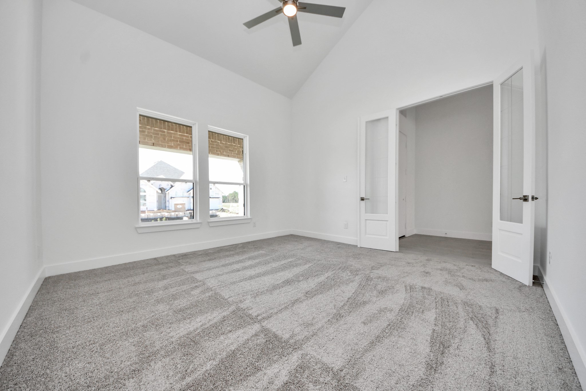 Experience the perfect blend of sophistication and warmth in this home office, flooded with natural light from expansive windows and French doors.