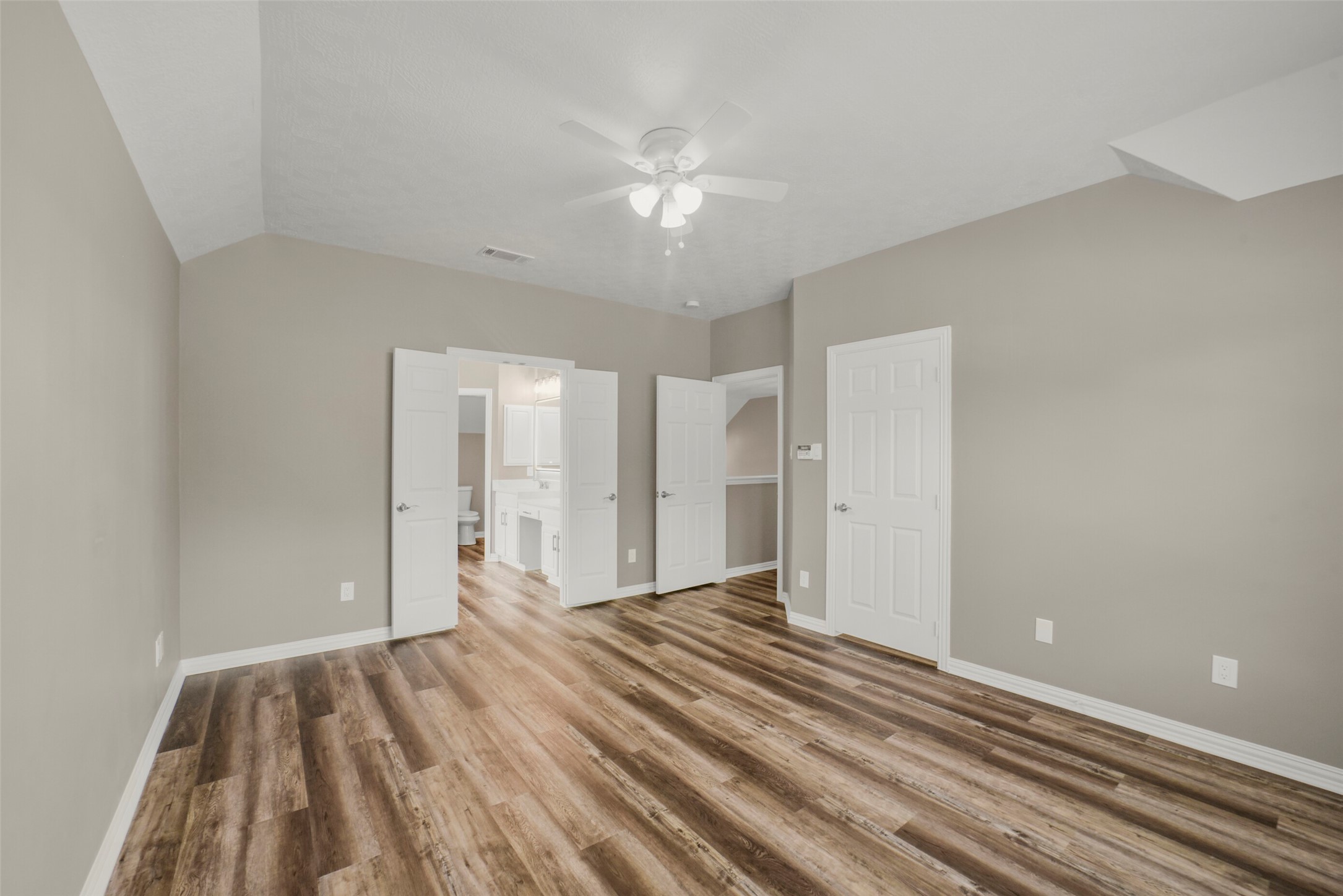 An alternate view of the primary suite underscores the generous layout and features one of two closets, providing exceptional storage space right off the bedroom area.