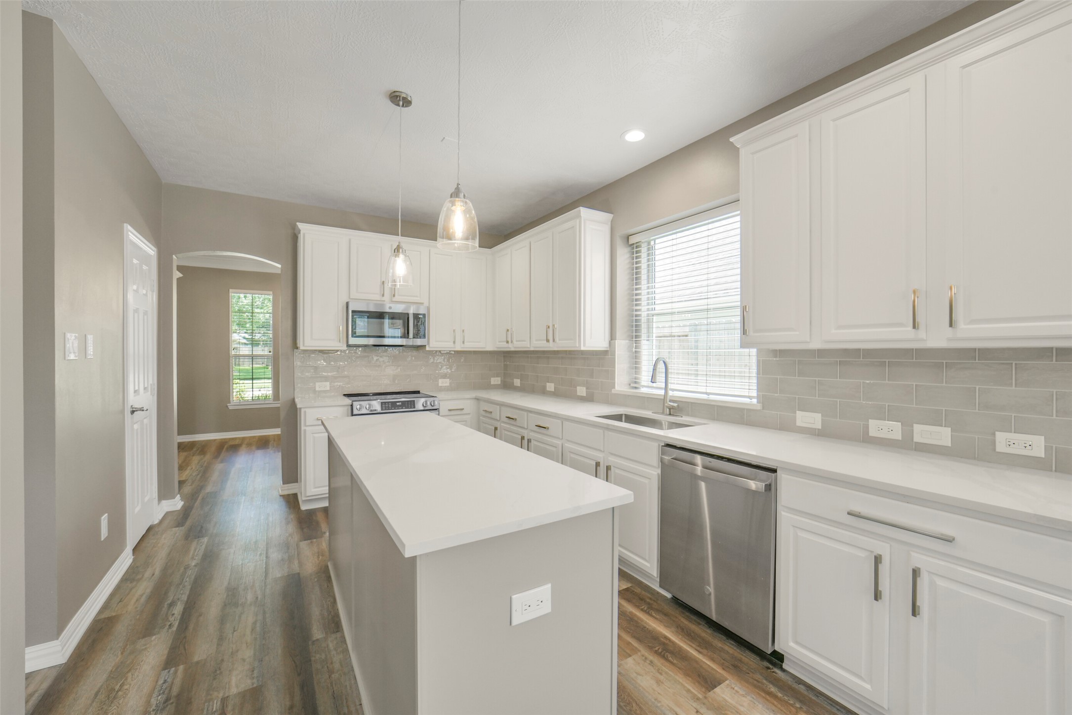 The gourmet kitchen features stainless steel appliances, a large island perfect for prepping, and seamless connectivity to the formal dining room.
