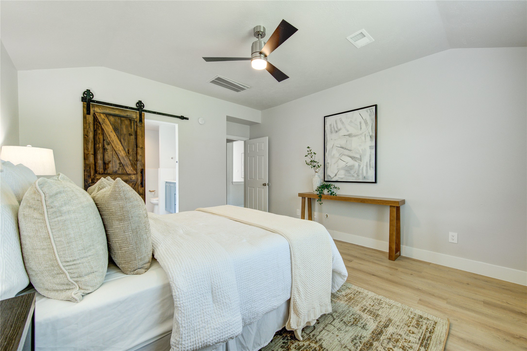 Primary retreat featuring contemporary ceiling fan and private access to the en-suite bathroom