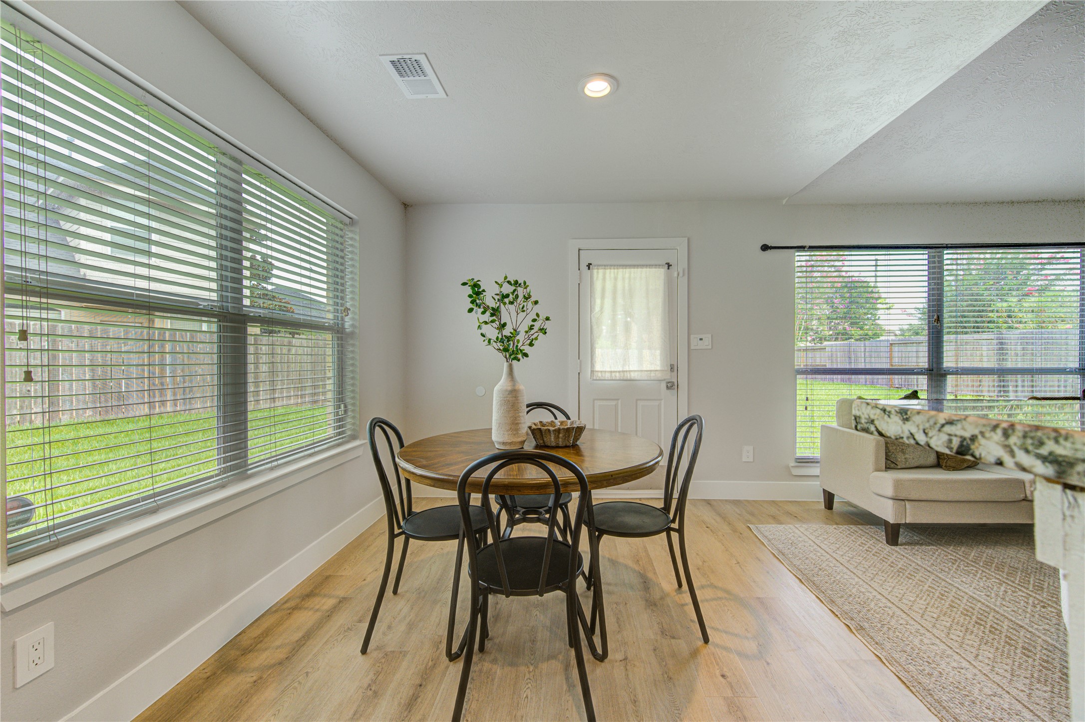 The breakfast area is surrounded by natural light and offers direct access to the covered patio, making indoor-outdoor dining simple and convenient