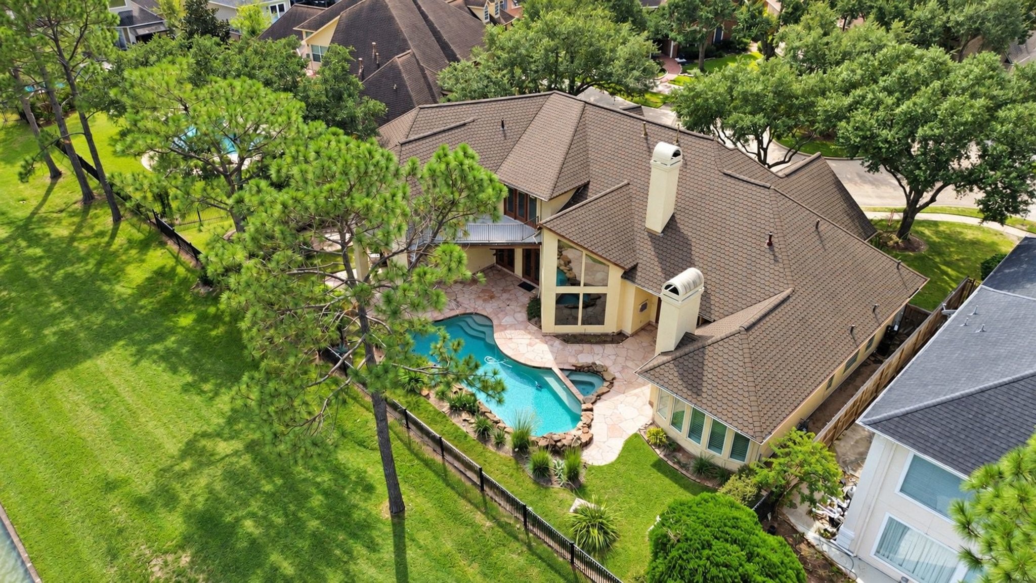 This stunning aerial view highlights the expansive and meticulously manicured backyard, showcasing a perfect balance of lush green lawn and mature, professionally curated landscaping that provides both beauty and privacy!