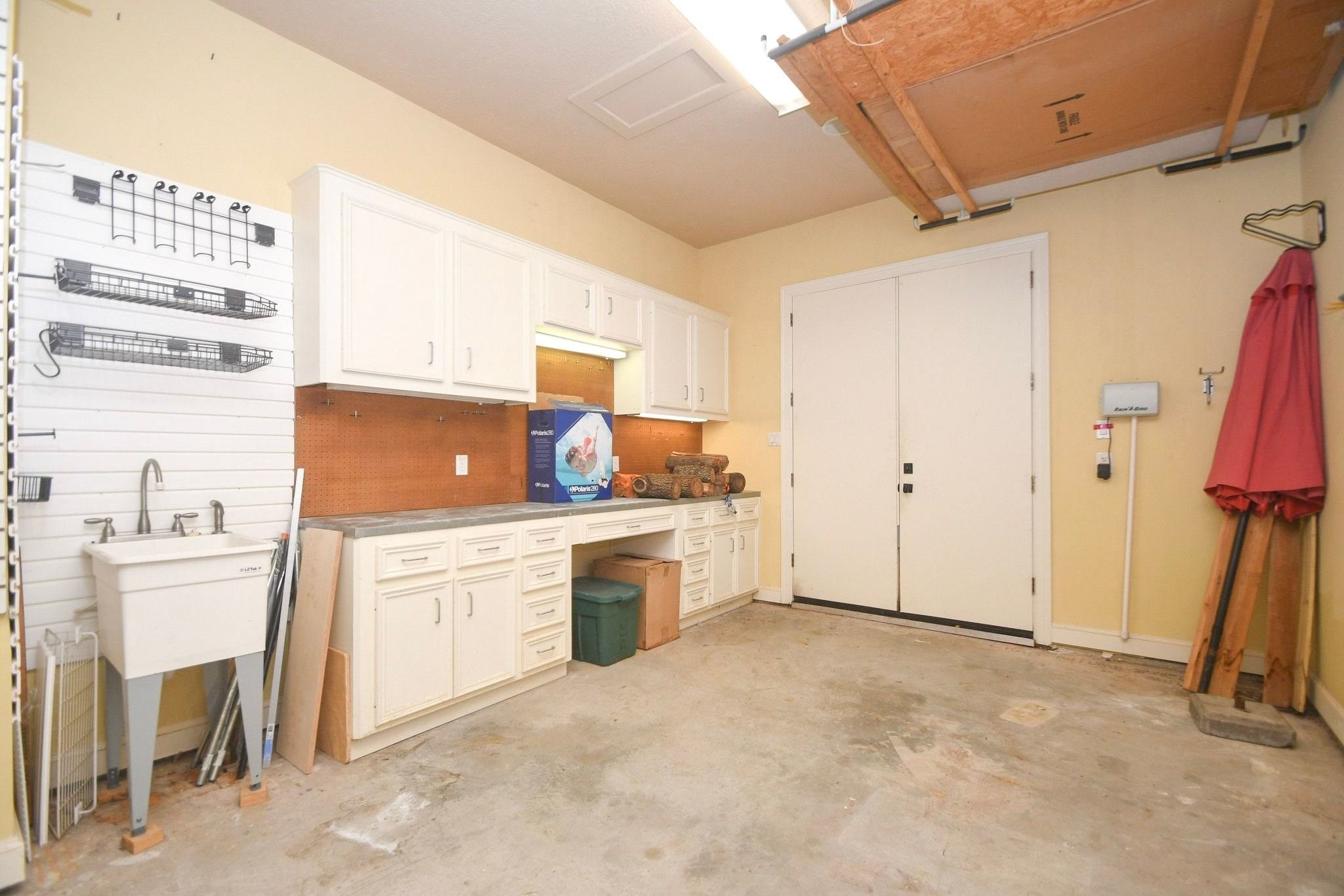 Third bay of the garage features a dedicated workbench and a utility sink!