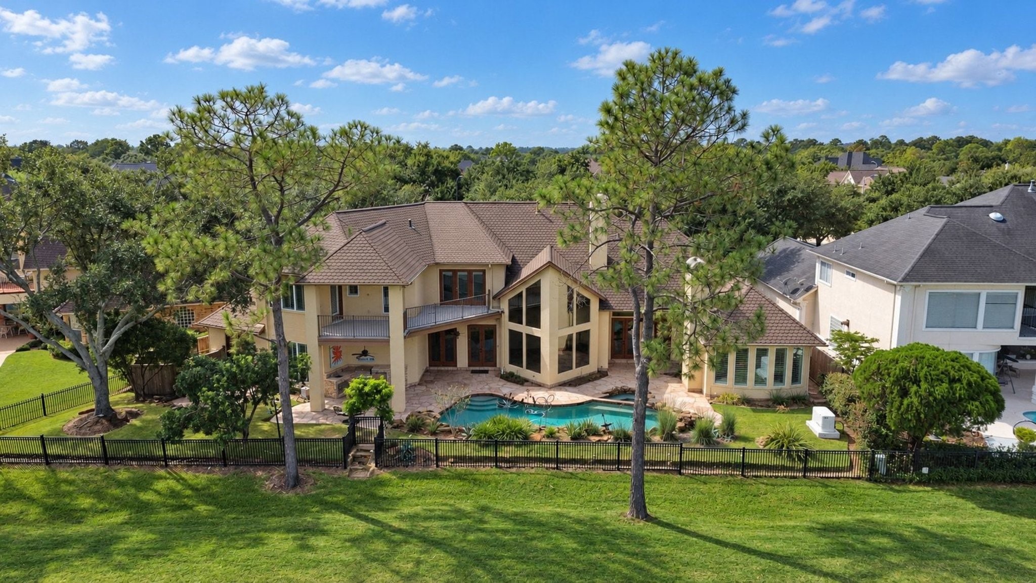 This image highlights the stunning back view of the property, showcasing the expansive, well-maintained backyard alongside the meticulously curated professional landscaping that enhances the overall curb appeal and charm of this lovely home!