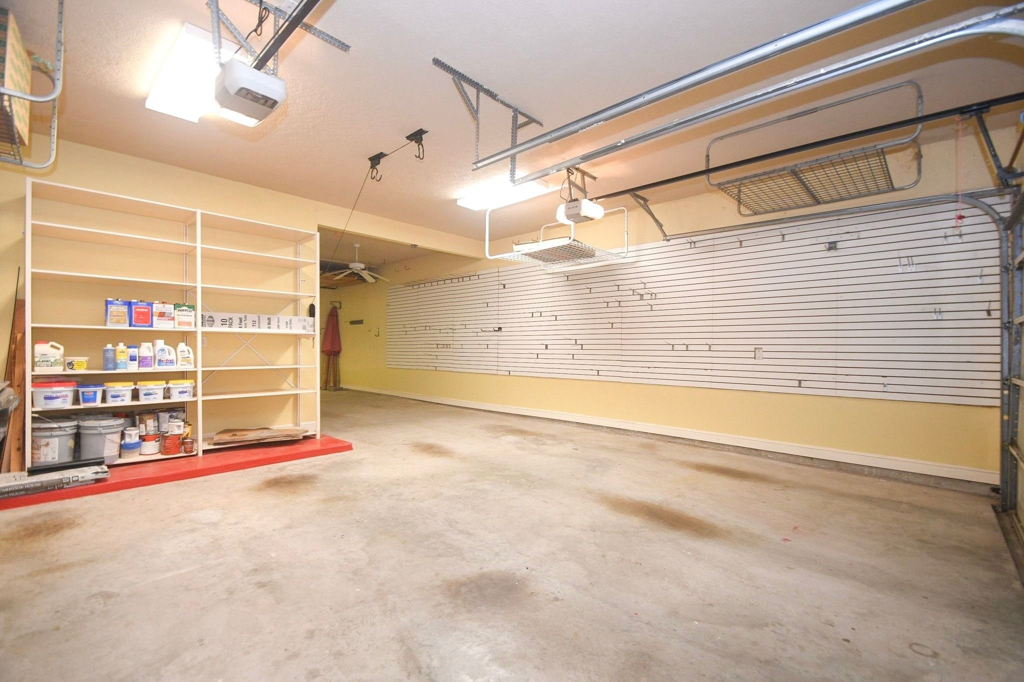 Spacious 3-car garage featuring extensive custom pegboard storage organization, ideal for workshop projects and equipment management!