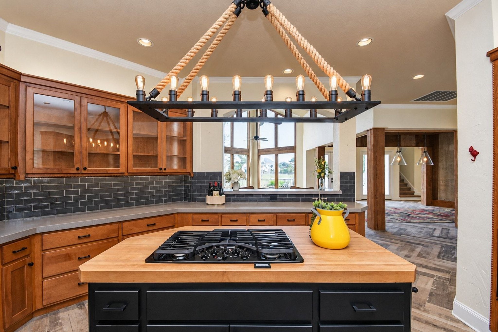 Lovely kitchen featuring custom lighting, abundant cabinet space, and expansive countertops!