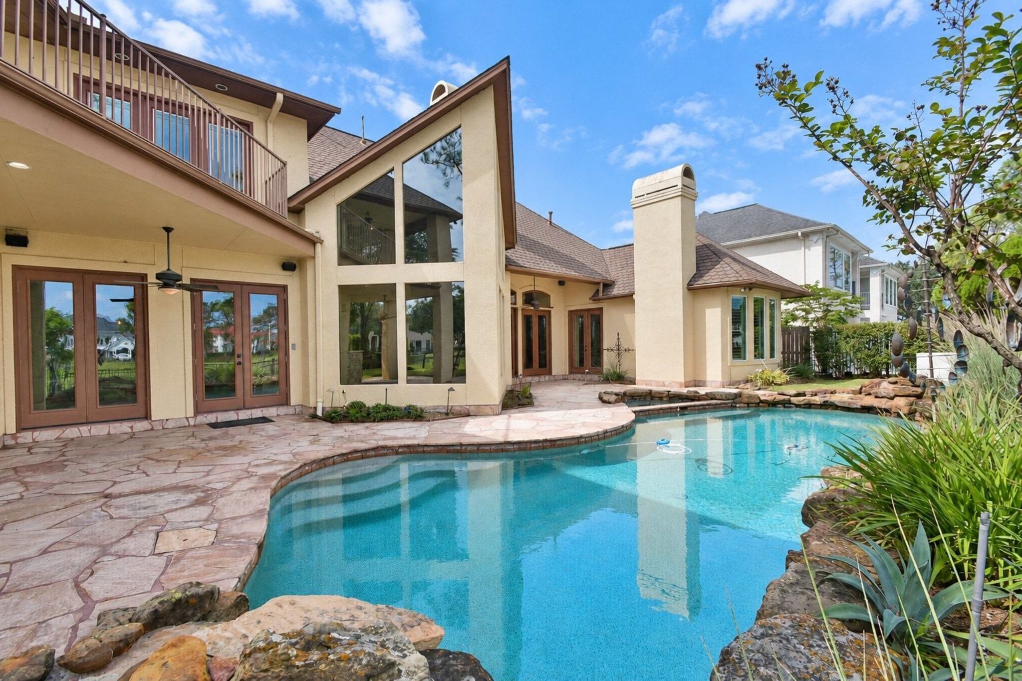 Beautiful custom pool perfect for entertaining, featuring professional landscaping, integrated lighting, and a spacious deck area designed for hosting guests!
