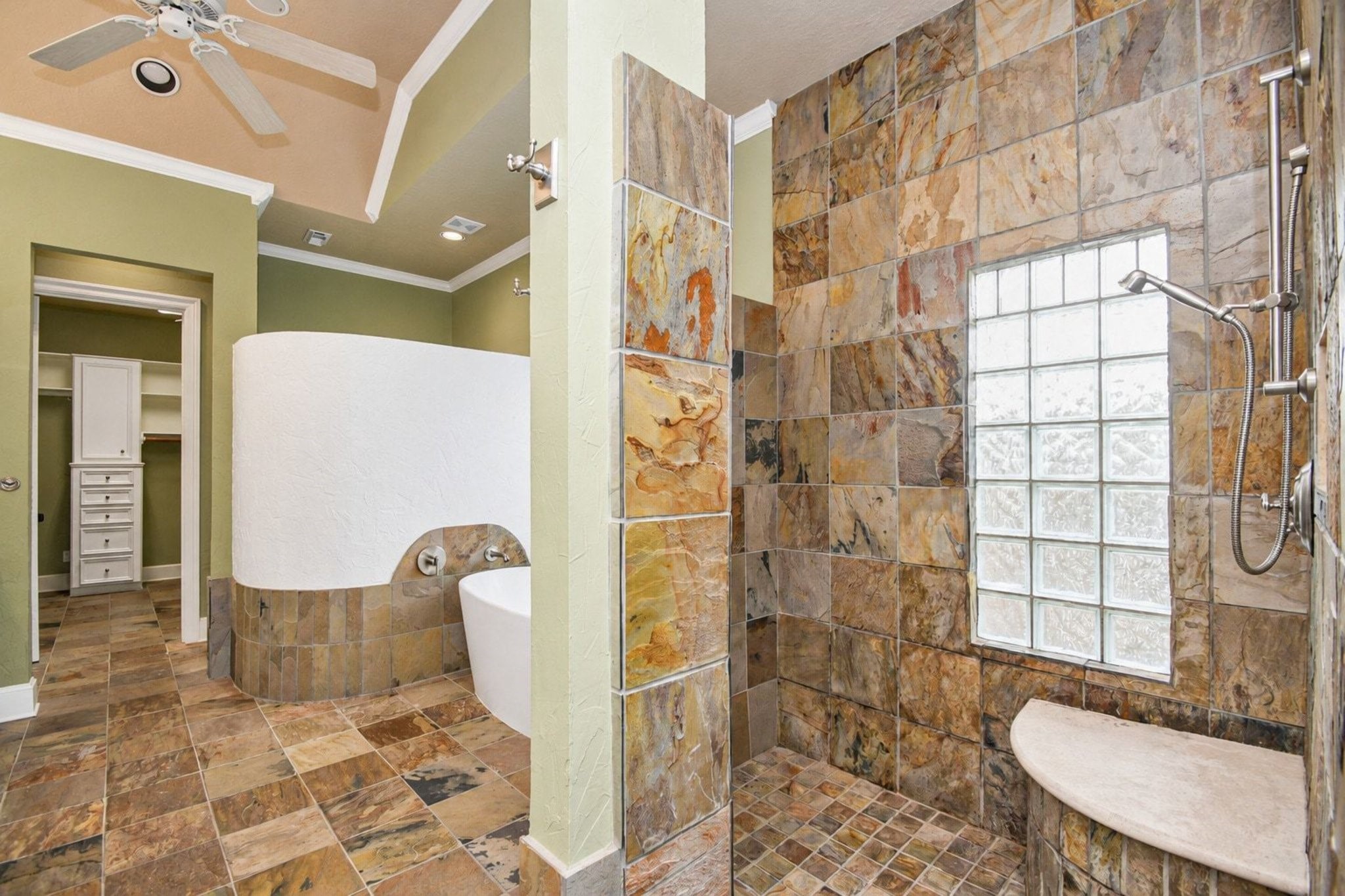 Step into the primary ensuite, a true sanctuary designed for ultimate relaxation and refined comfort. This master bath features sophisticated block glass windows that elegantly invite an abundance of natural light while ensuring complete privacy from the exterior!
