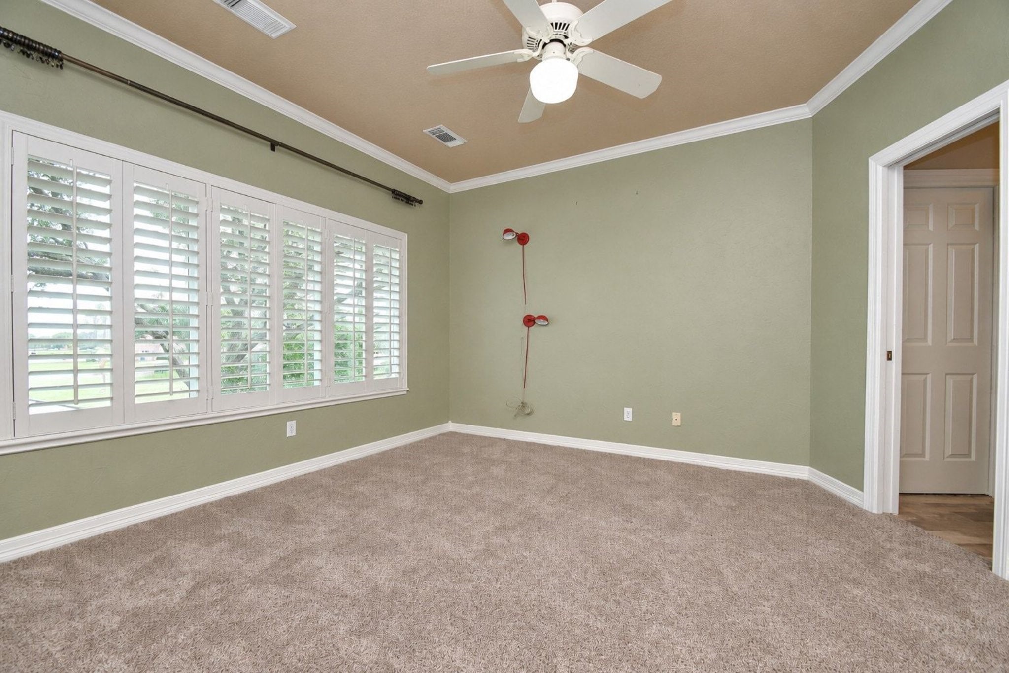 This spacious secondary bedroom features plush carpeting, neutral paint tones, and large windows that provide abundant natural light. The room offers ample space for a queen-sized bed and additional furniture, complemented by a generous walk-in closet with built-in organizational shelving. Ideal for a guest room, home office, or kids' retreat, this space provides a comfortable and versatile layout!