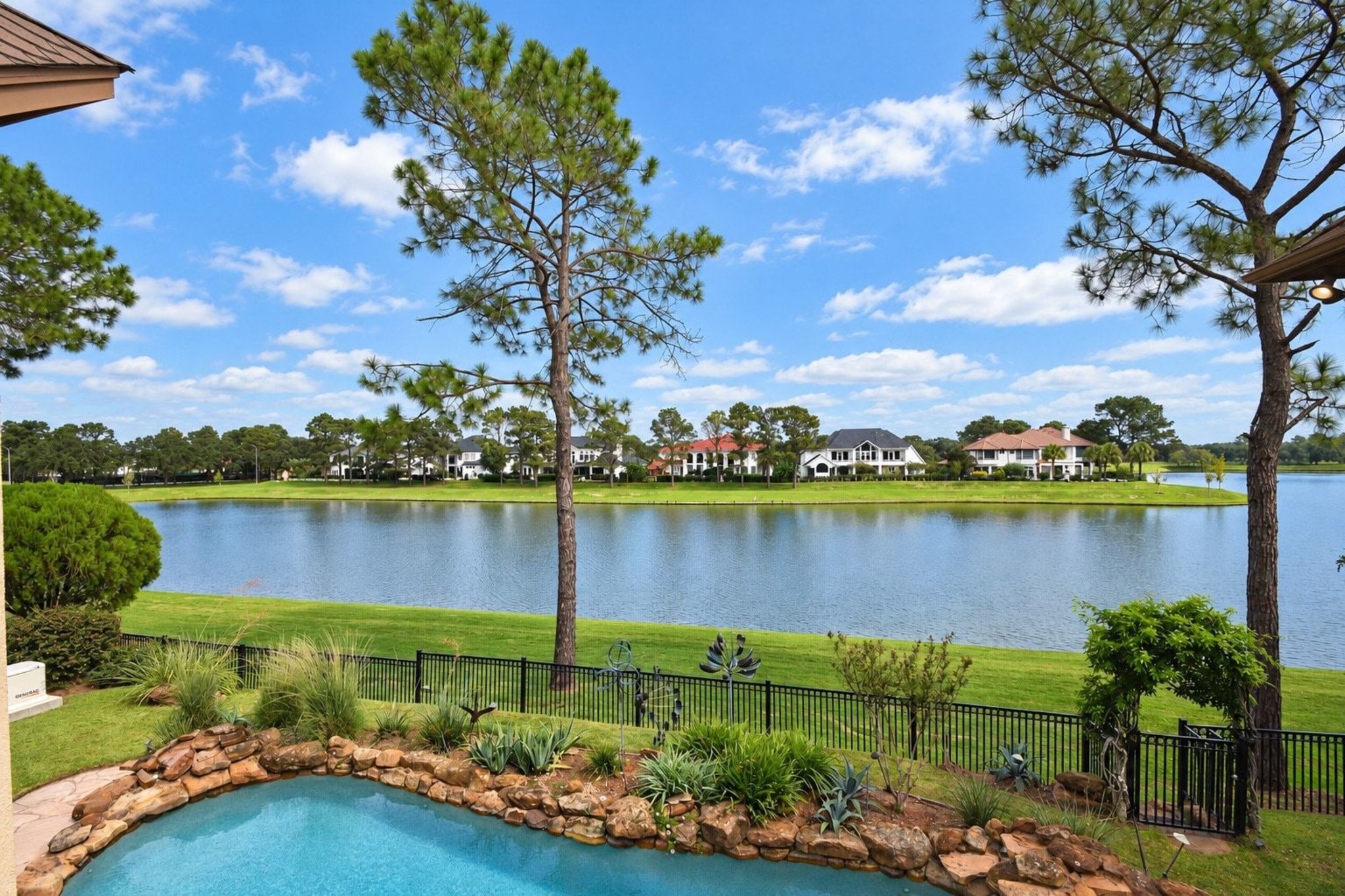 Views from your back yard of the lake and pool! This stunning outdoor oasis features expansive water views and a pristine swimming pool, perfect for entertaining or relaxing in your own private sanctuary. The seamless integration of the pool area with the natural beauty of the lake creates a serene and picturesque backdrop for everyday living!