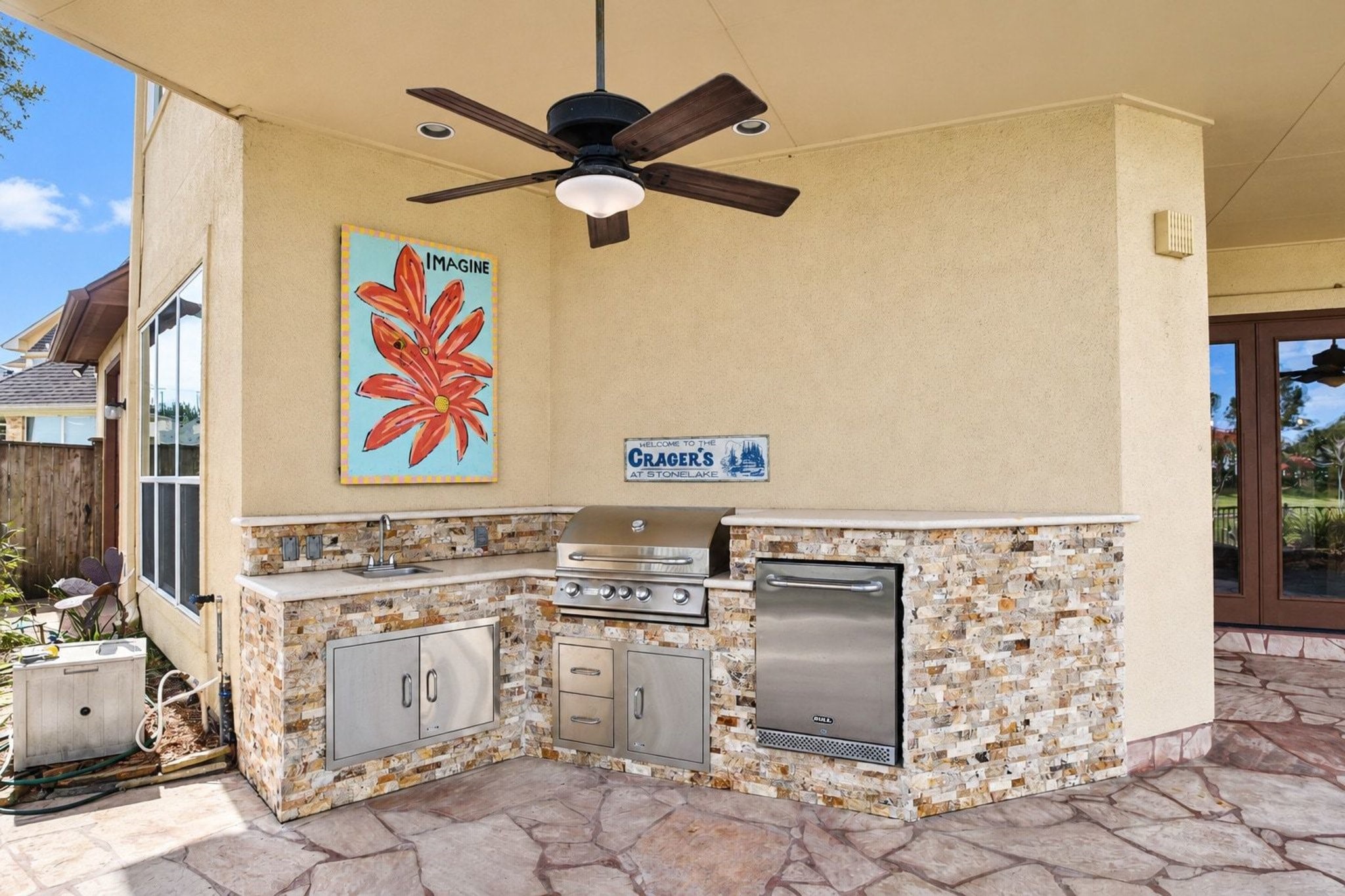 This stunning, professional-grade outdoor kitchen serves as the ultimate entertainer's paradise. It features premium high-end appliances, including a top-of-the-line grill, complemented by durable and elegant stone countertops. The space is expertly designed with integrated seating, creating a seamless and inviting atmosphere that is perfect for hosting summer gatherings, alfresco dining, or relaxed evenings with family and friends!