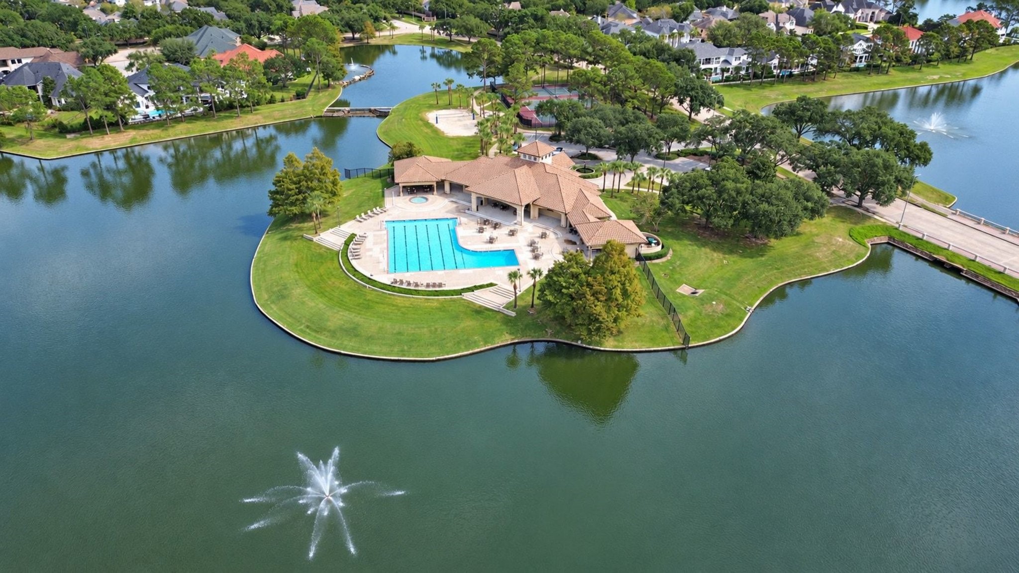 Aerial view of the community pool and recreation center, showcasing the resort-style amenities and expansive lounge areas available to residents!