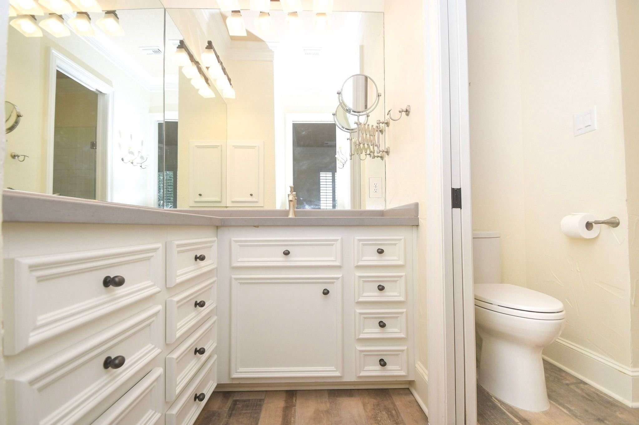 This upstairs bathroom has been beautifully upgraded to feature elegant, high-end custom cabinetry that provides ample storage space, perfectly complemented by sleek, modern fixtures and contemporary hardware that add a touch of sophisticated style to the overall design of the room!