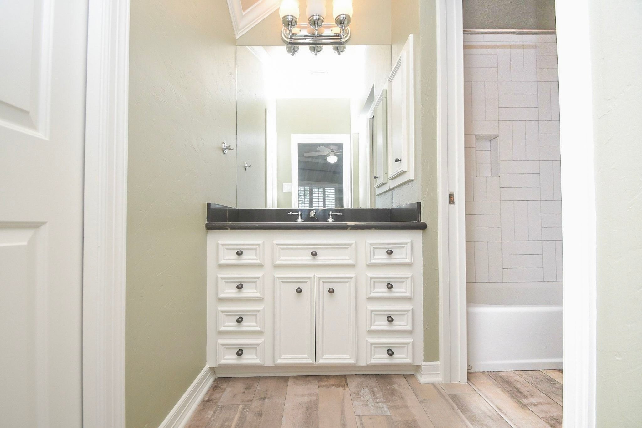 Beautifully upstairs full bathroom featuring a modern vanity, elegant flooring, and a spacious walk-in shower/tub combination with premium finishes!