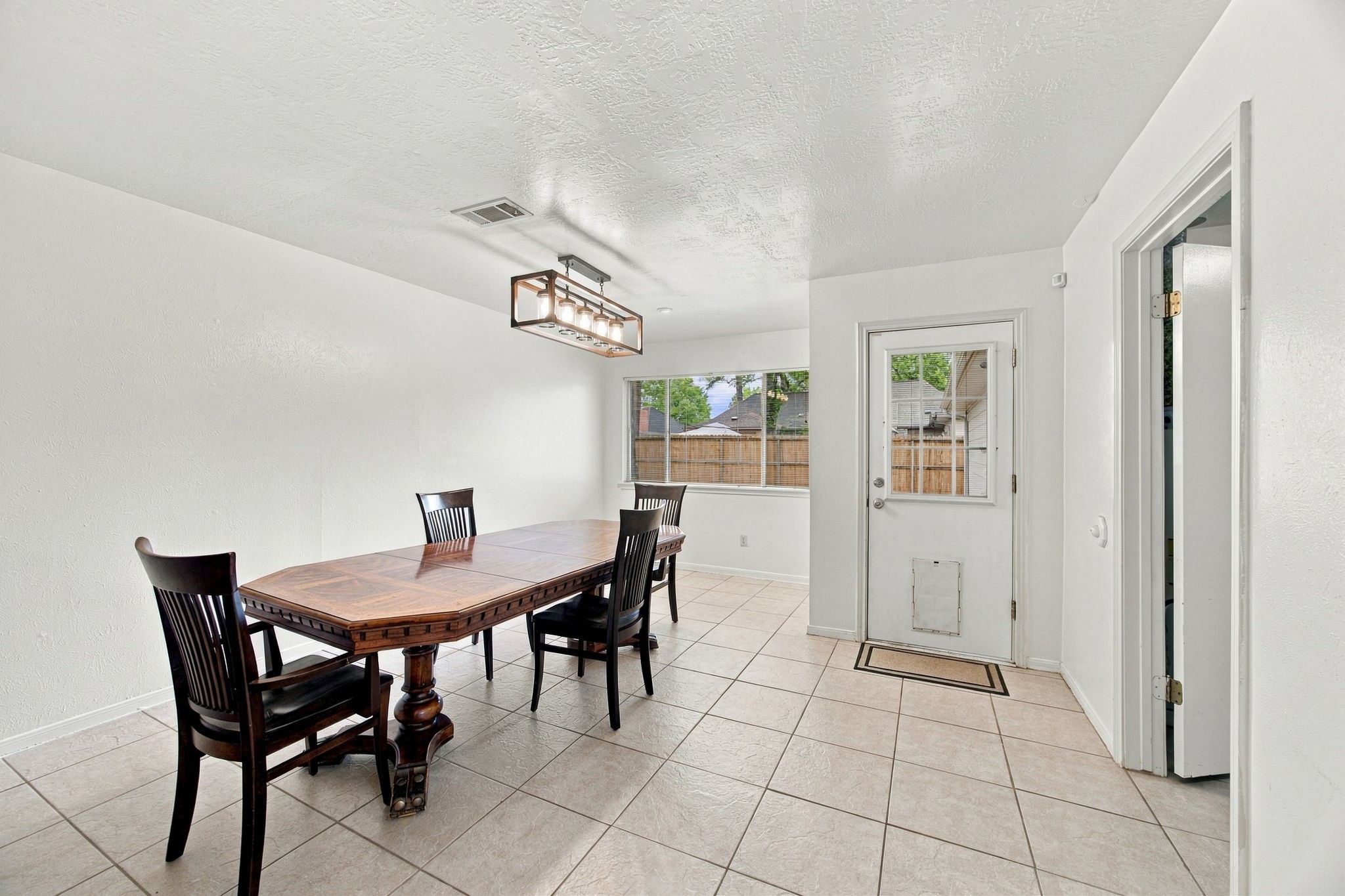 This large dining room has room for all your furniture.  Laundry is the right and the back door leads to the yard and detached 3 car garage.