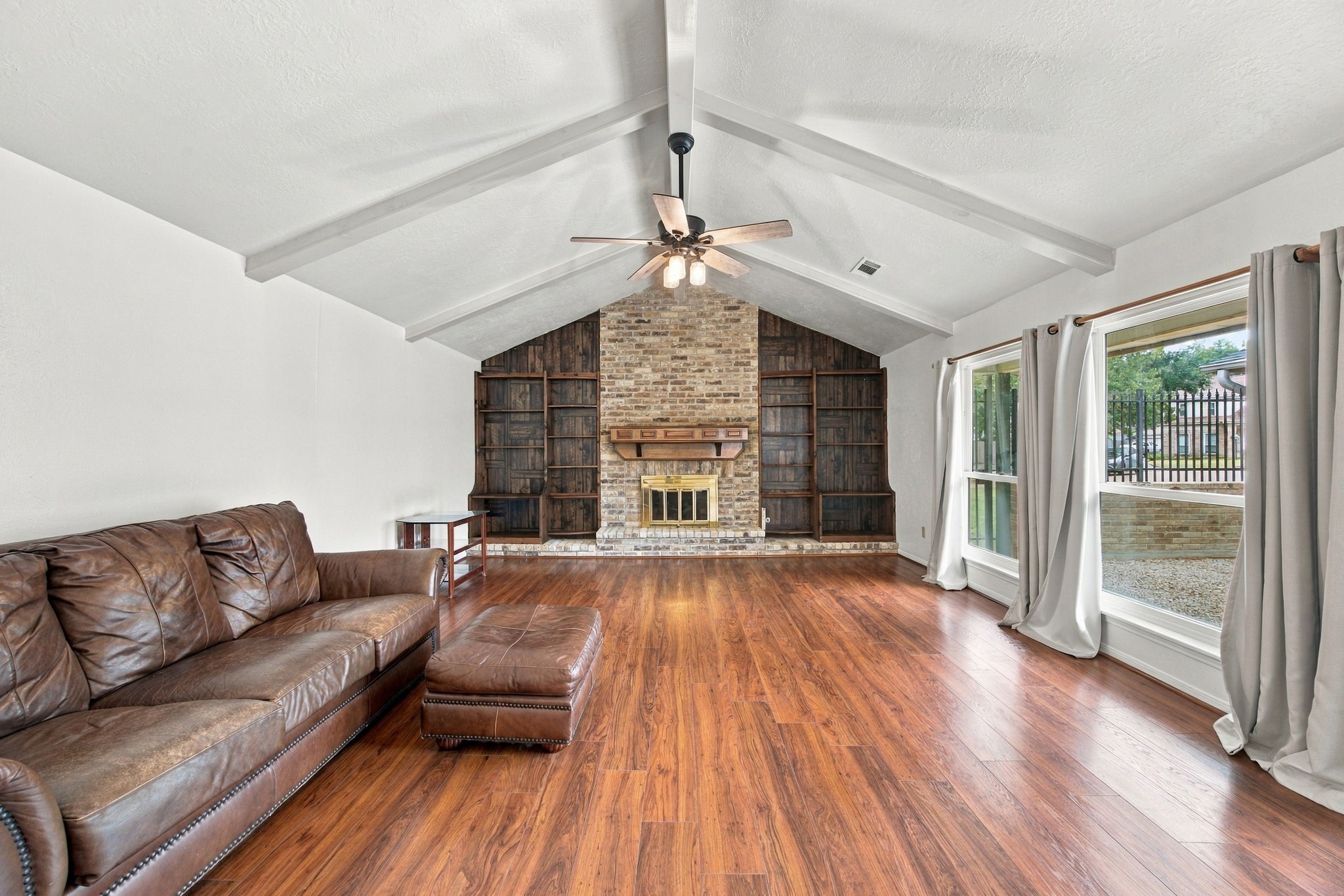 Extra-large living room with vaulted ceilings and built in bookshelves.  These windows are Anderson replacement windows.