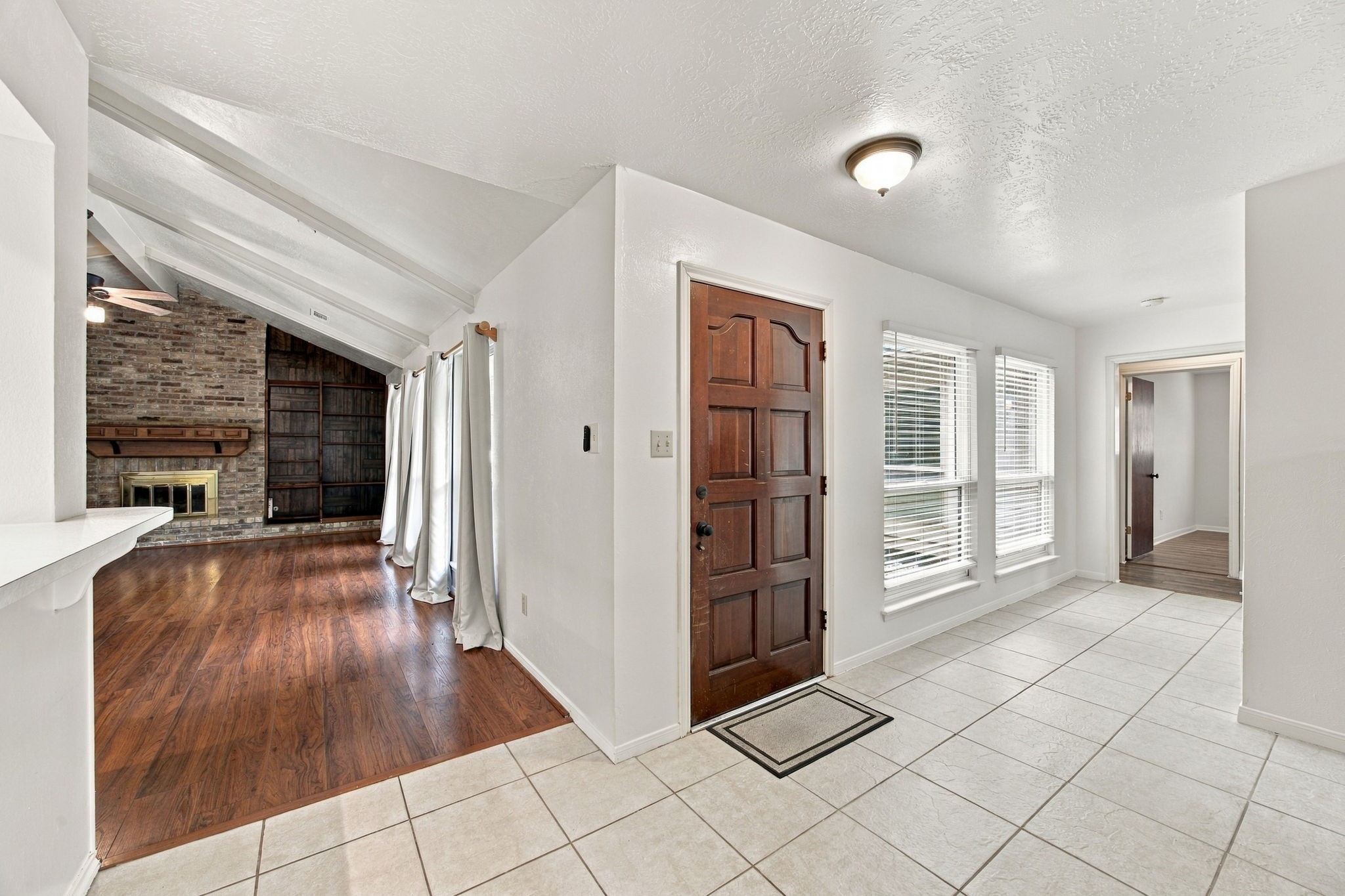 You enter in the middle of the home.  To the left (in this picture) is the living room ahead and the kitchen to the left.   Bedrooms are to the right. Dining room and laundry room are behind.