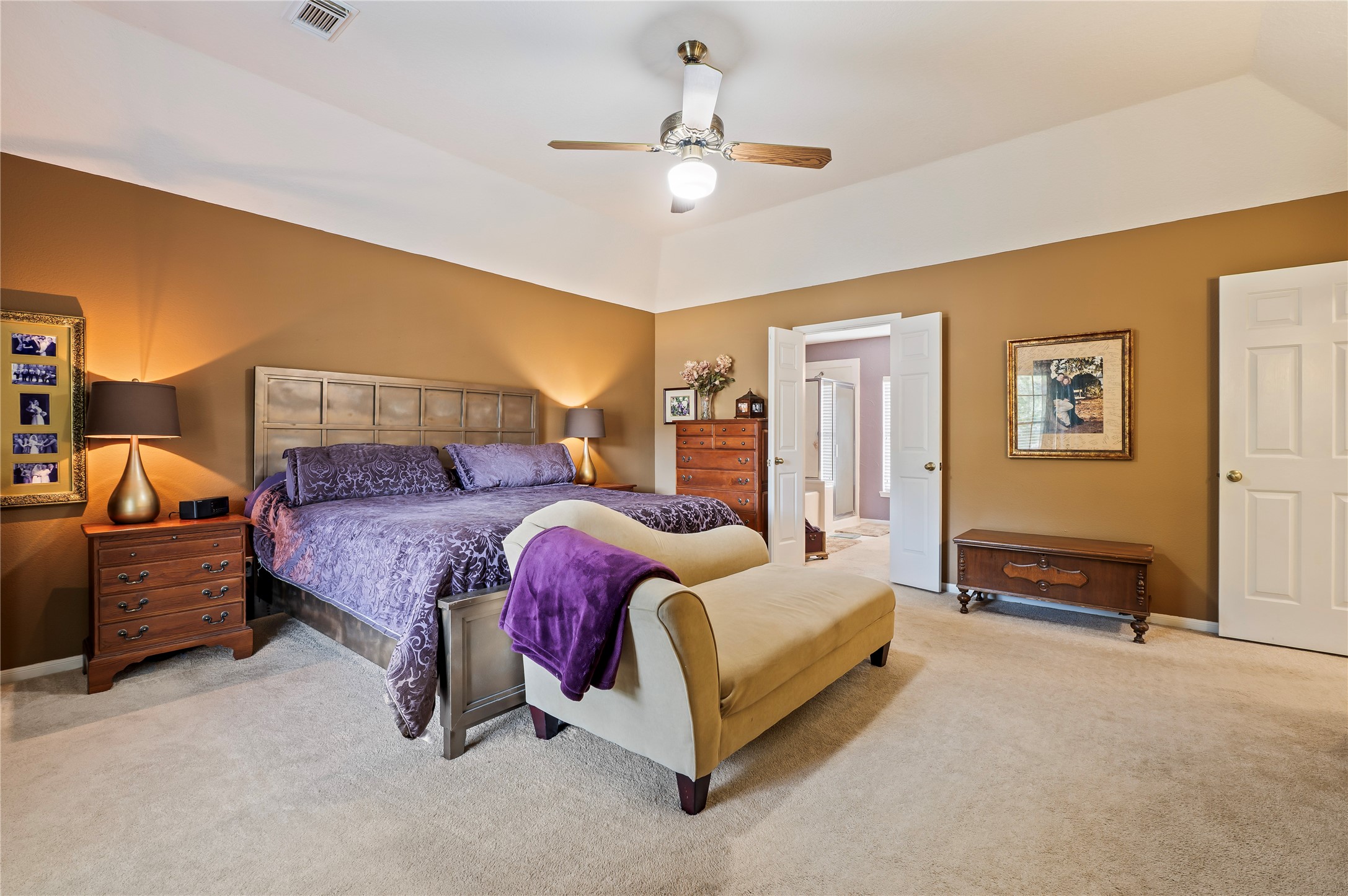 Another view of the primary bedroom with double doors to the primary bath.