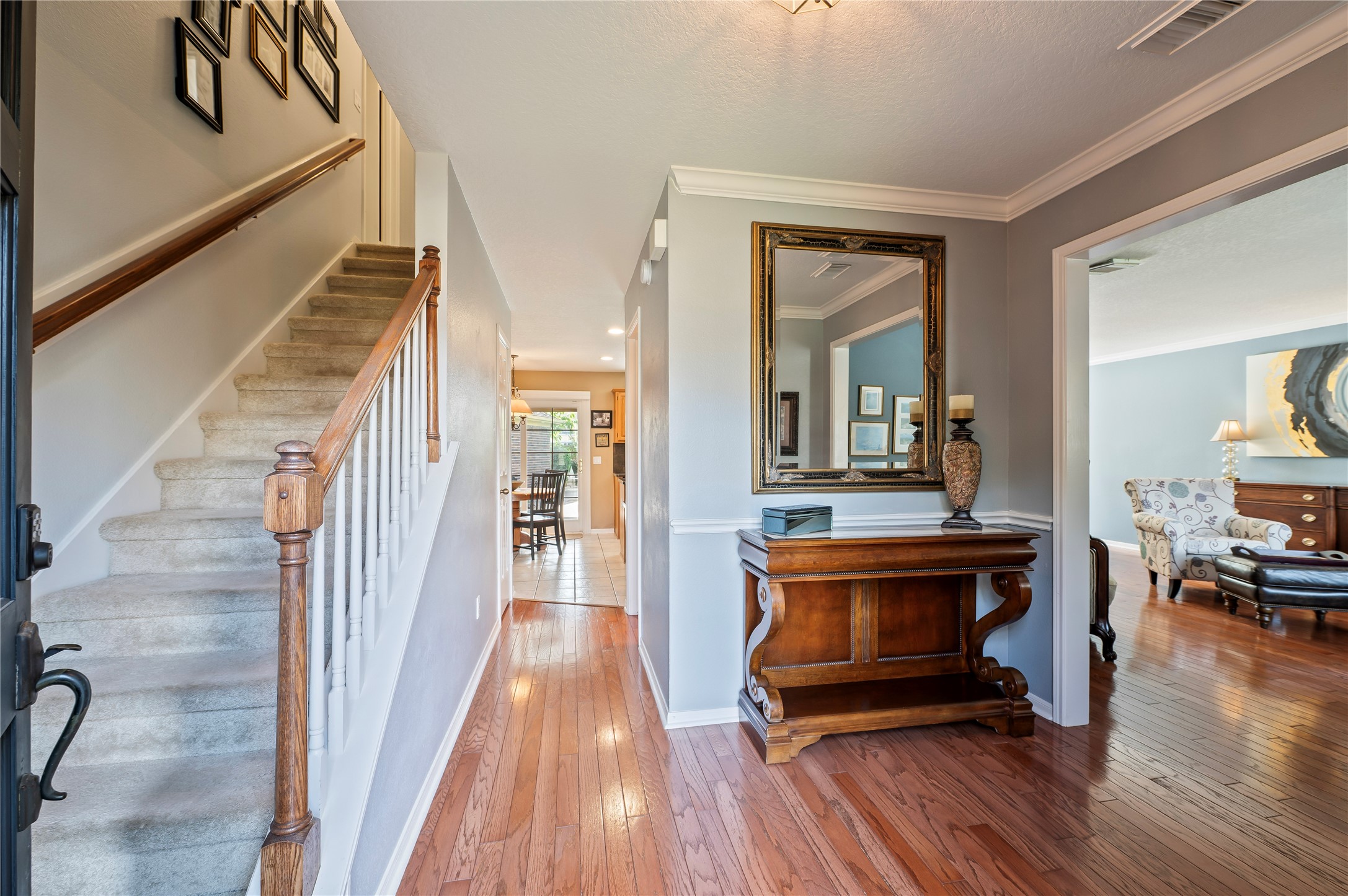 The foyer opens to the formal living room on the right, with crown molding and chair rail throughout.