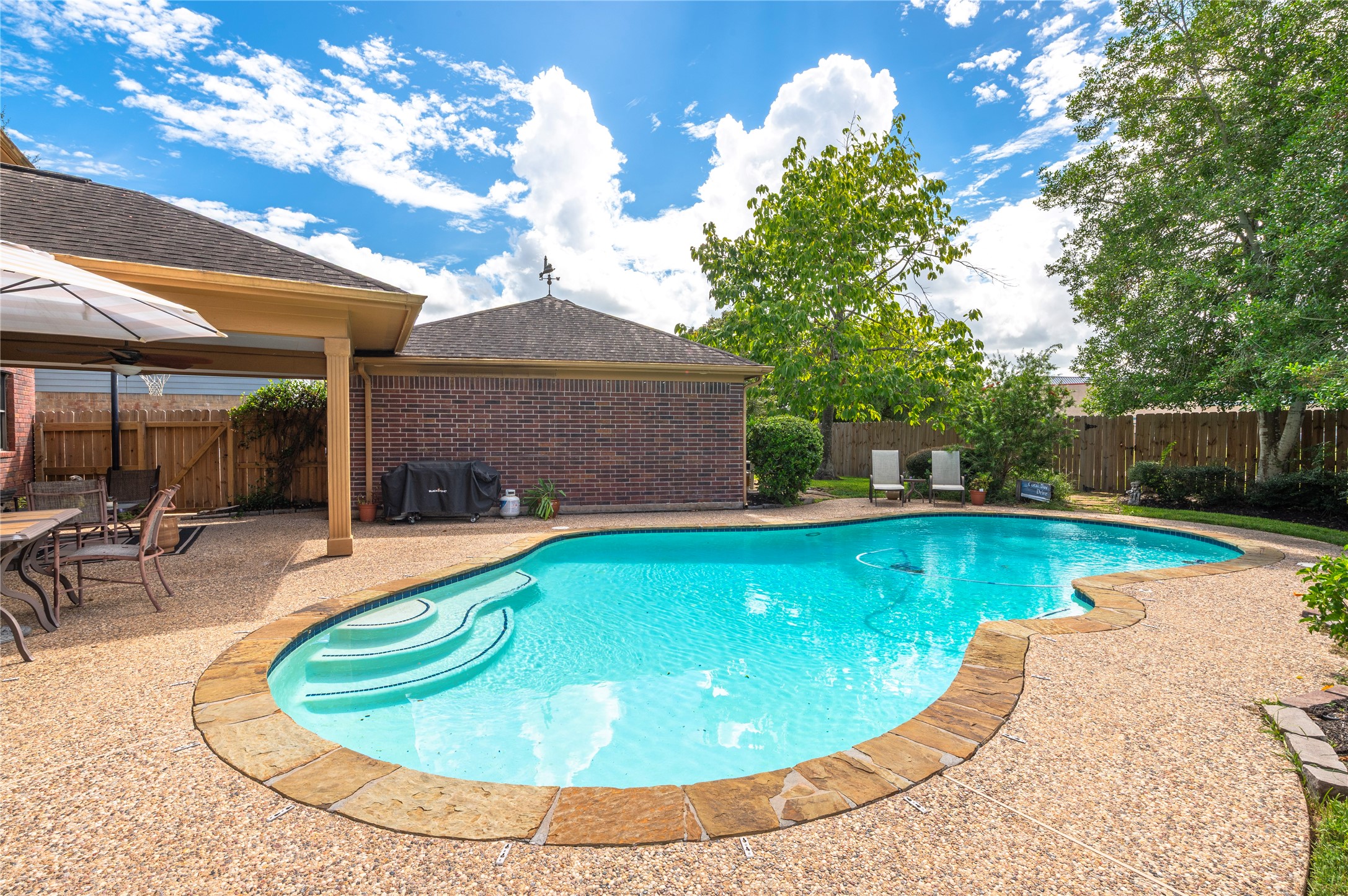 Easy step entry into the pool, with the detached garage just beyond the patio.