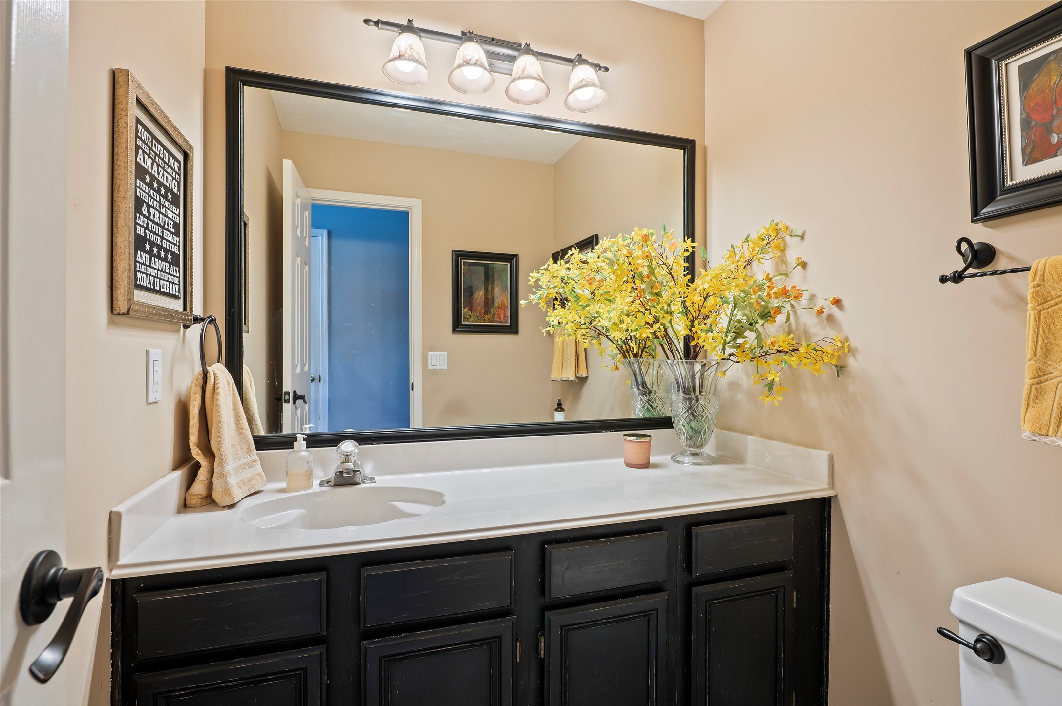 The larger-than-normal half bath downstairs has extra cabinet space and storage.