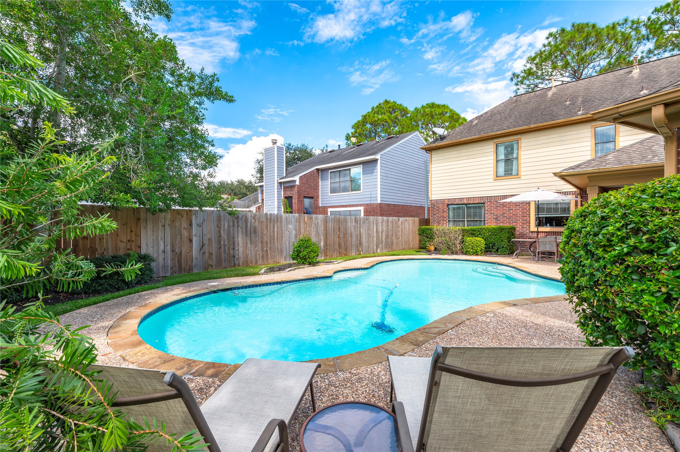 Lounge poolside under big shade trees.