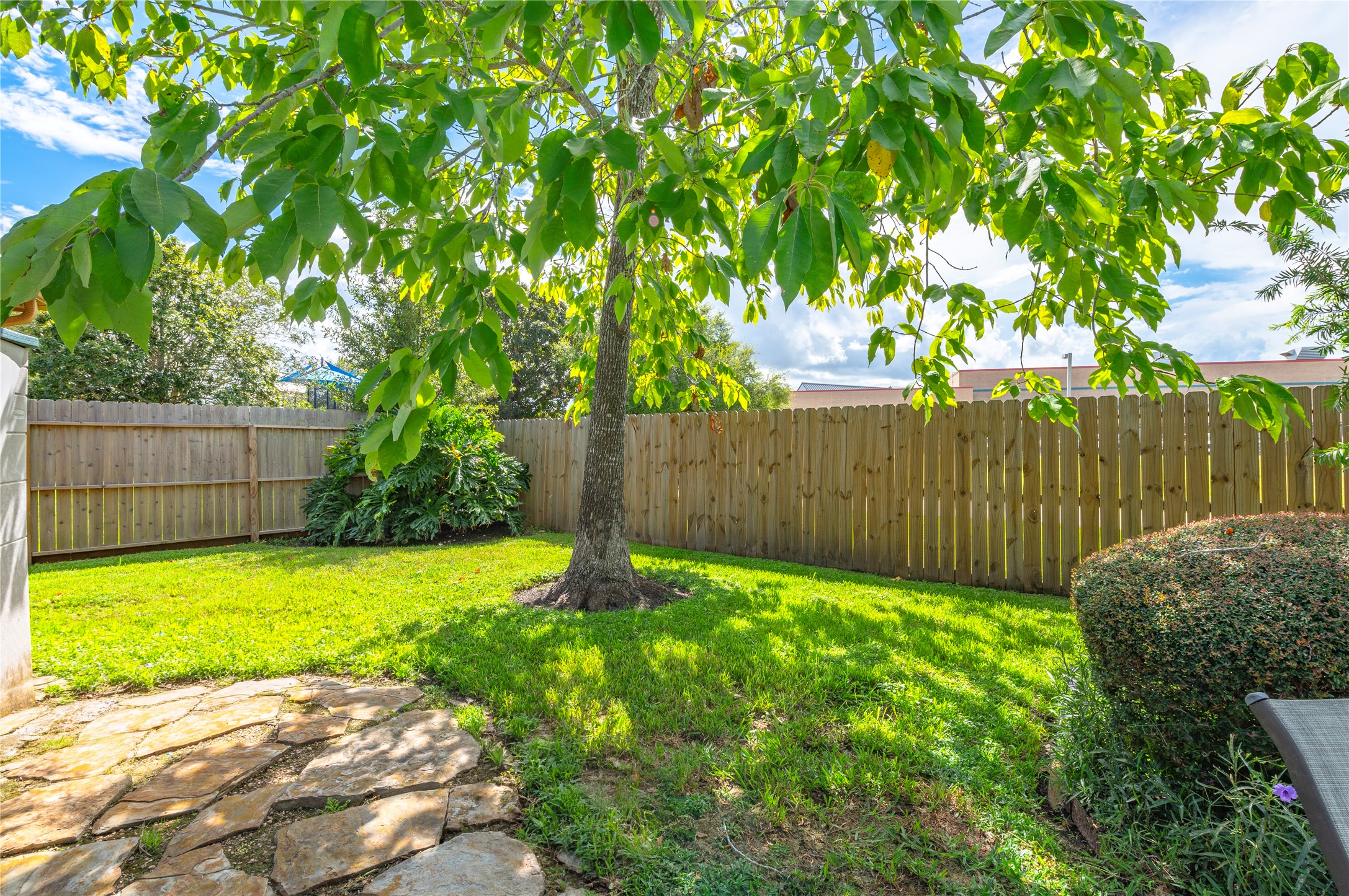 Lots of green space with a full sprinkler system, and a flagstone path leads to the back gate.