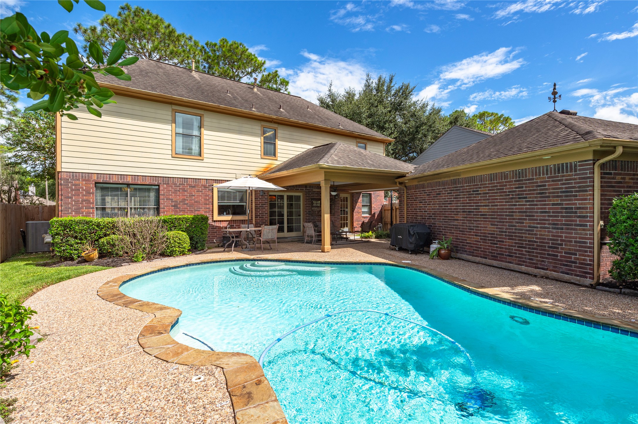 Gorgeous view of the back of the home with Hardie board siding and a sparkling pool.
