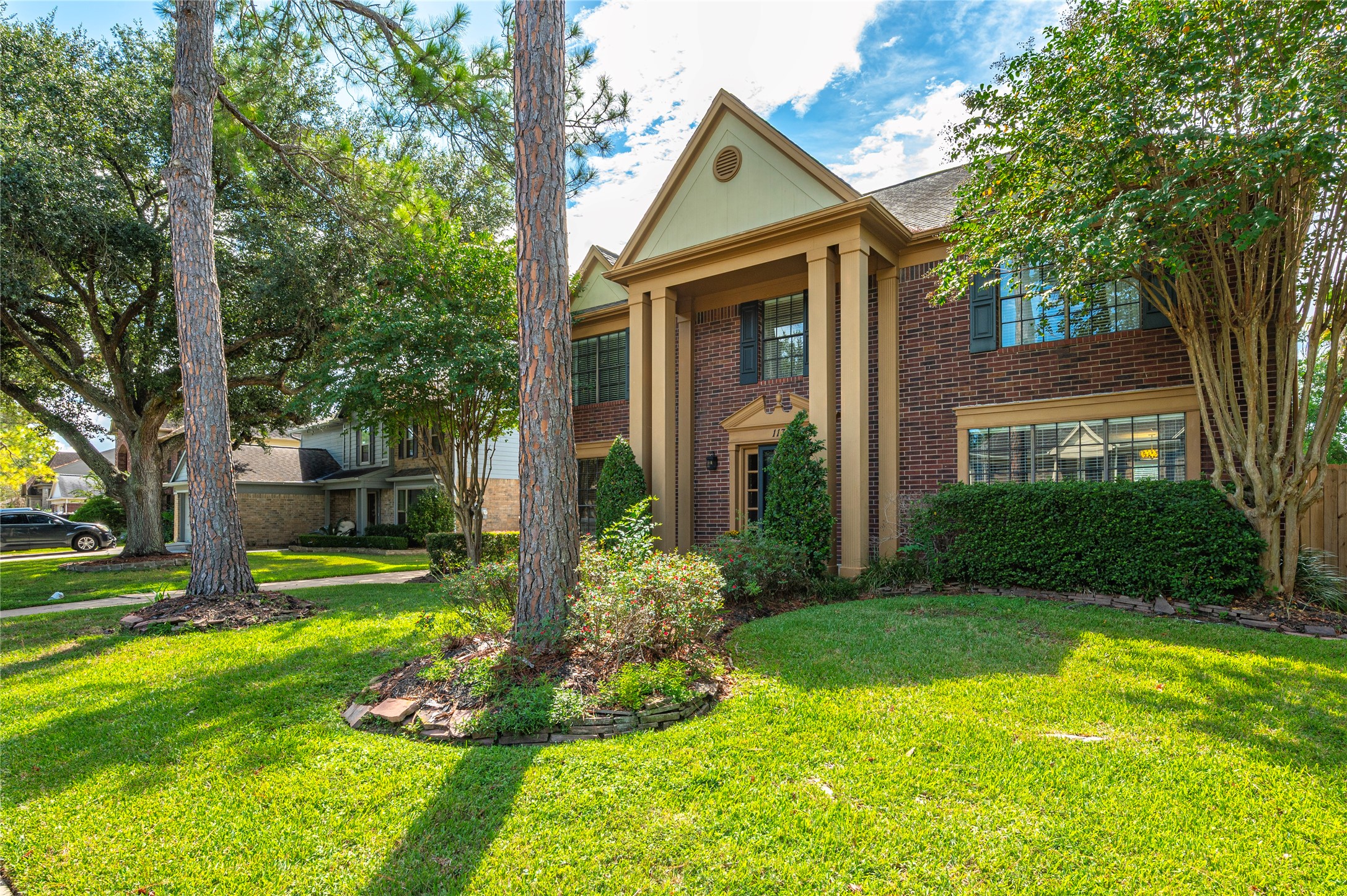 Landscaped beds around the mature trees give the front a true estate feel.