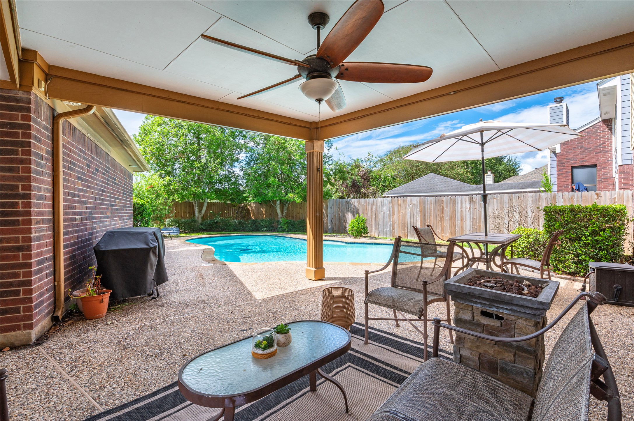 The covered porch looks right out to the pool and park-like backyard.