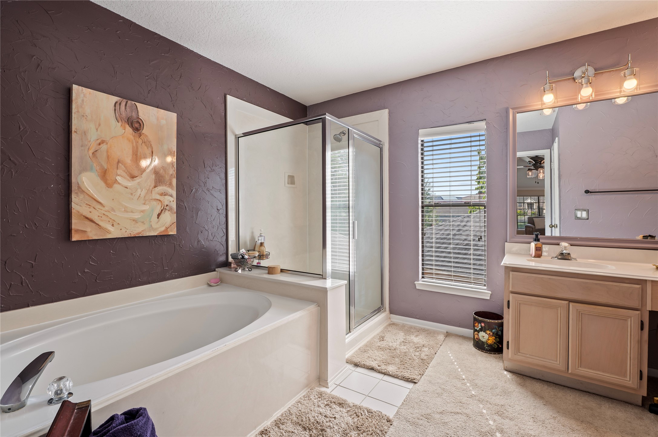 The primary bath has a garden tub and a separate glass-enclosed shower.