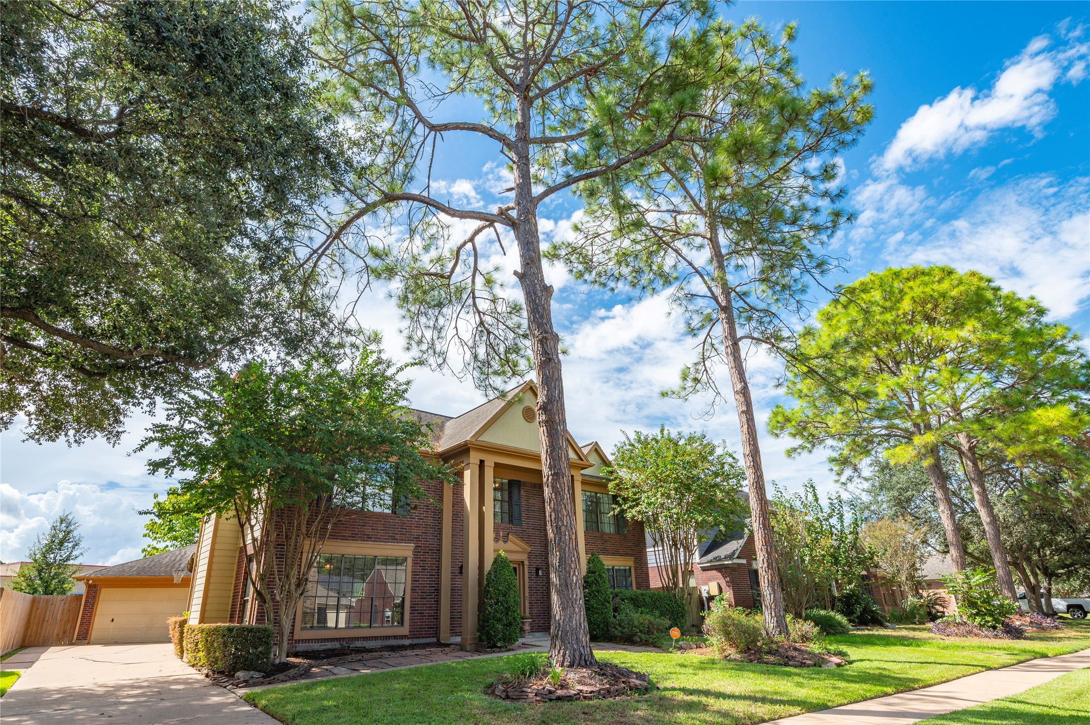 Towering pines and mature shade trees frame the home beautifully.