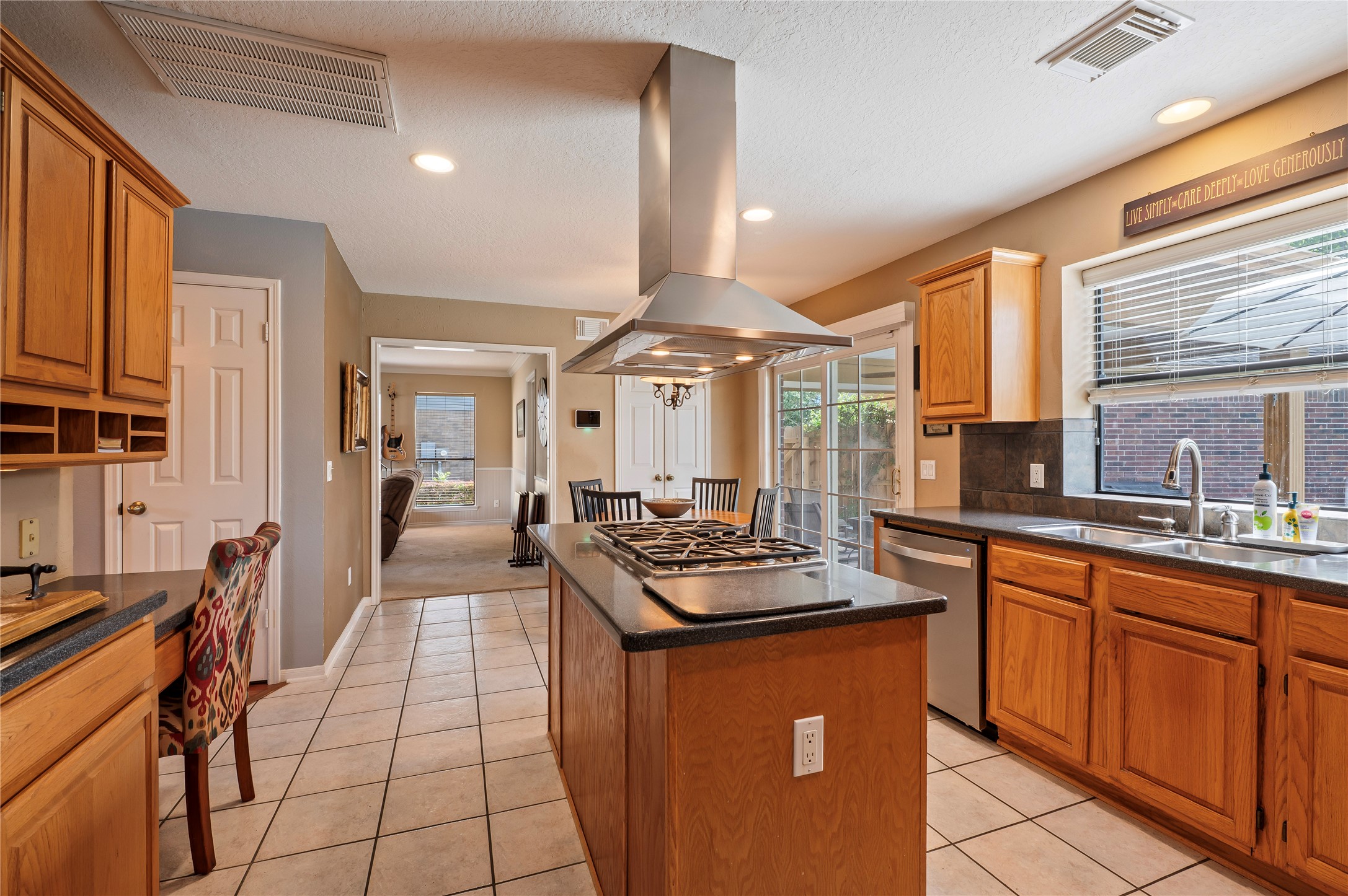 The kitchen sits at the center of the home with an island, storage galore and a built-in desk with cubbies.