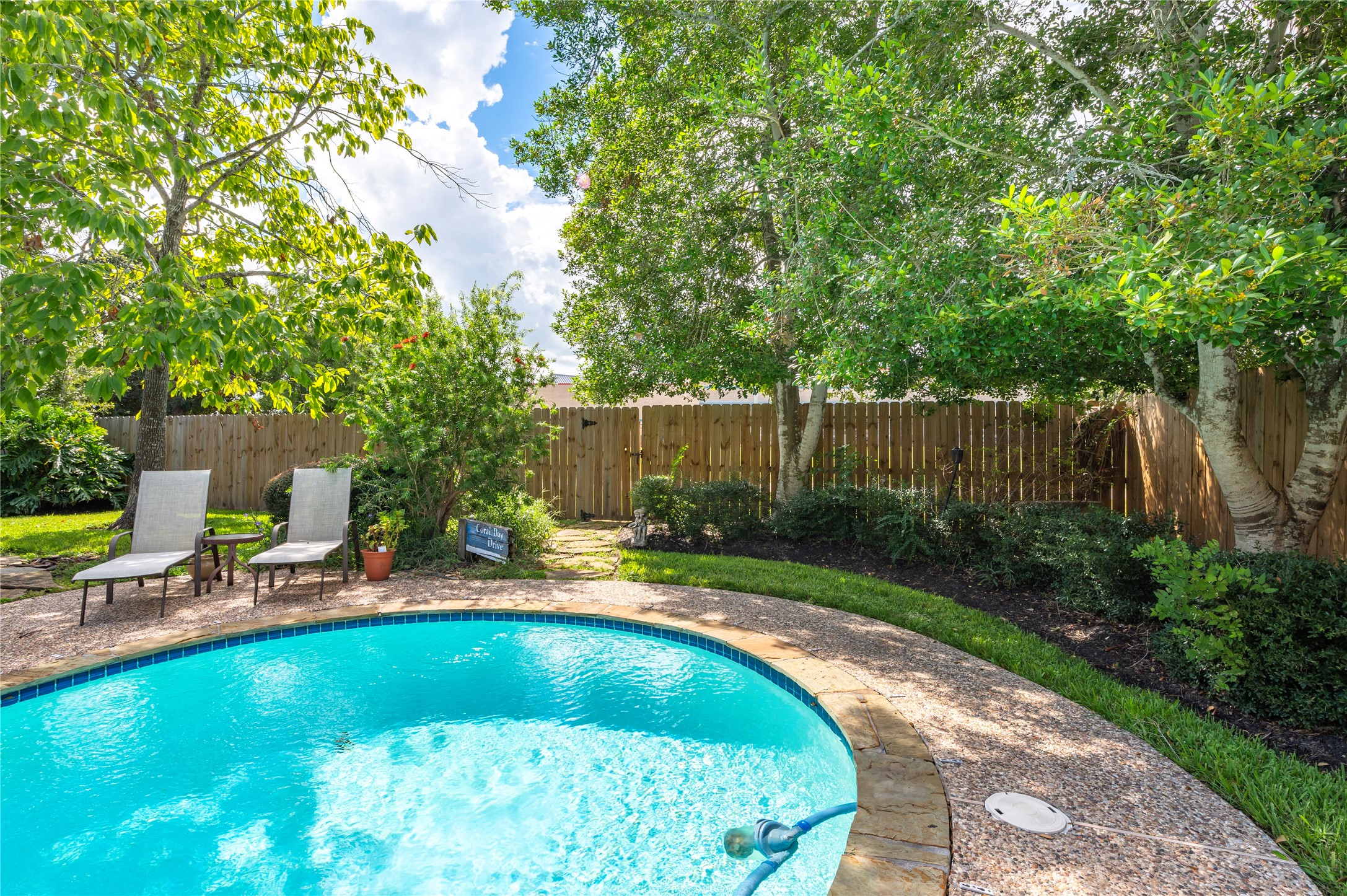 A shady corner by the pool with lush landscaping.