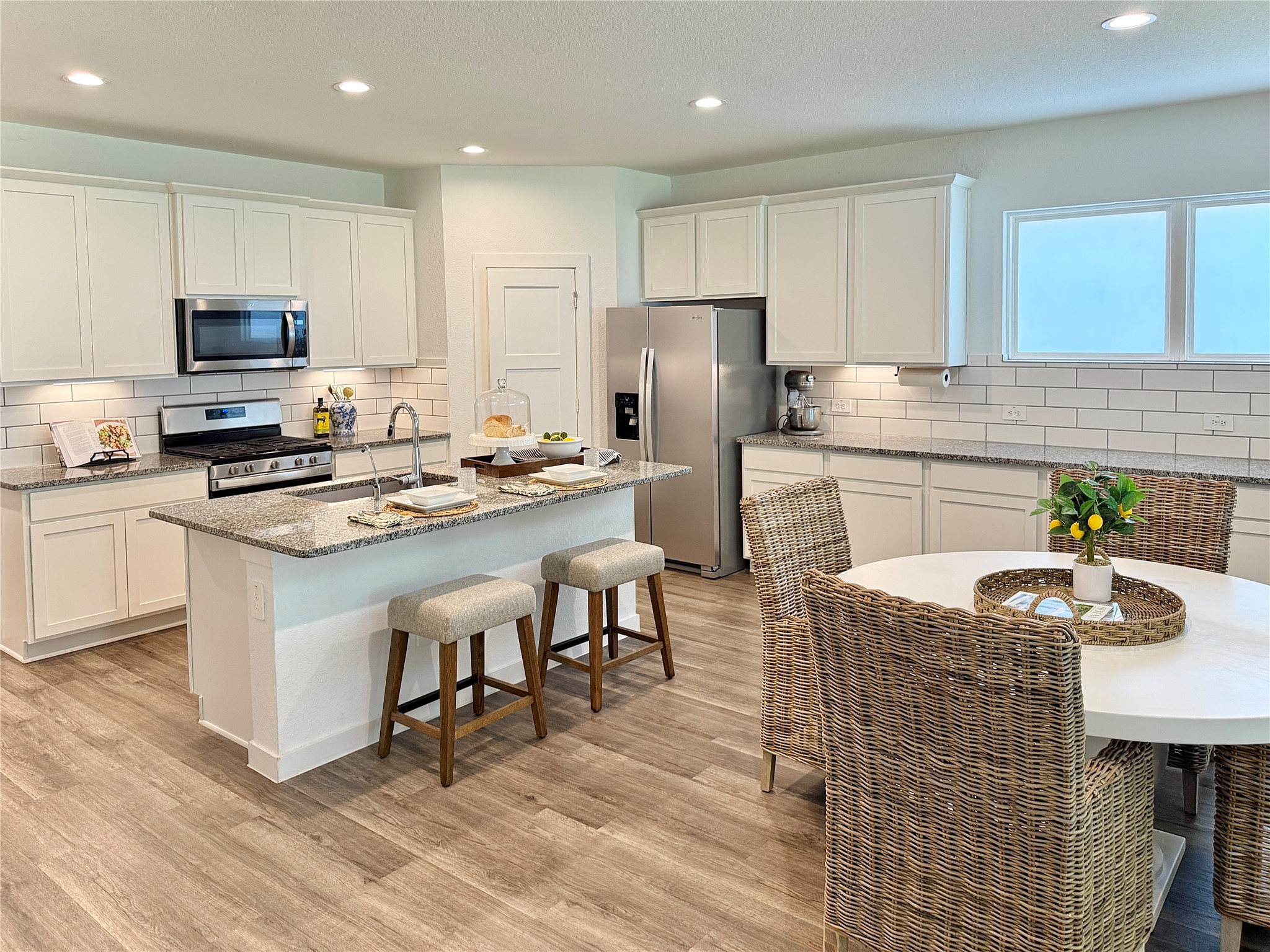 Bright and modern kitchen with granite countertops, stainless steel appliances, and a cozy breakfast nook