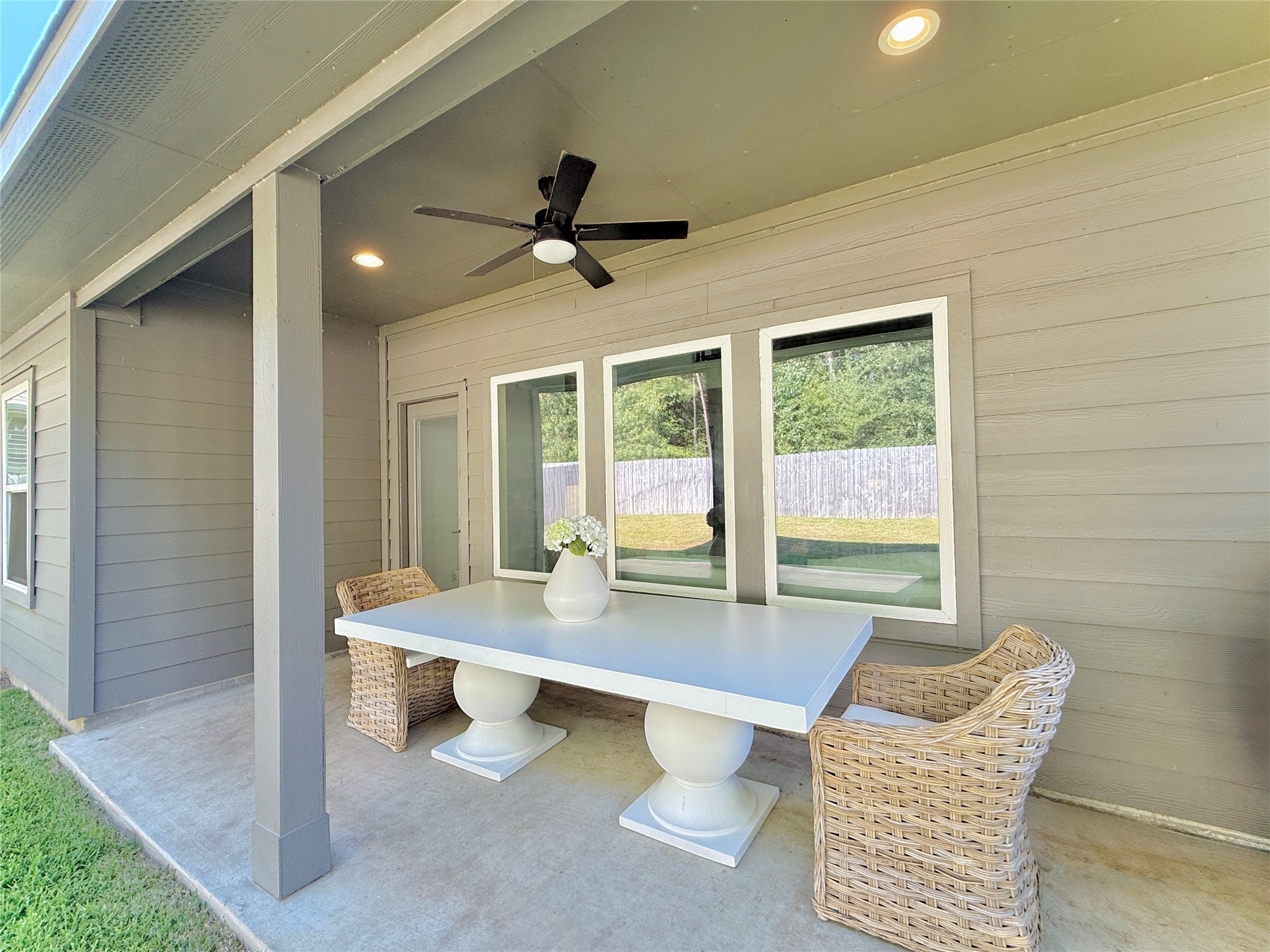 Covered patio with ceiling fan overlooking peaceful forrest