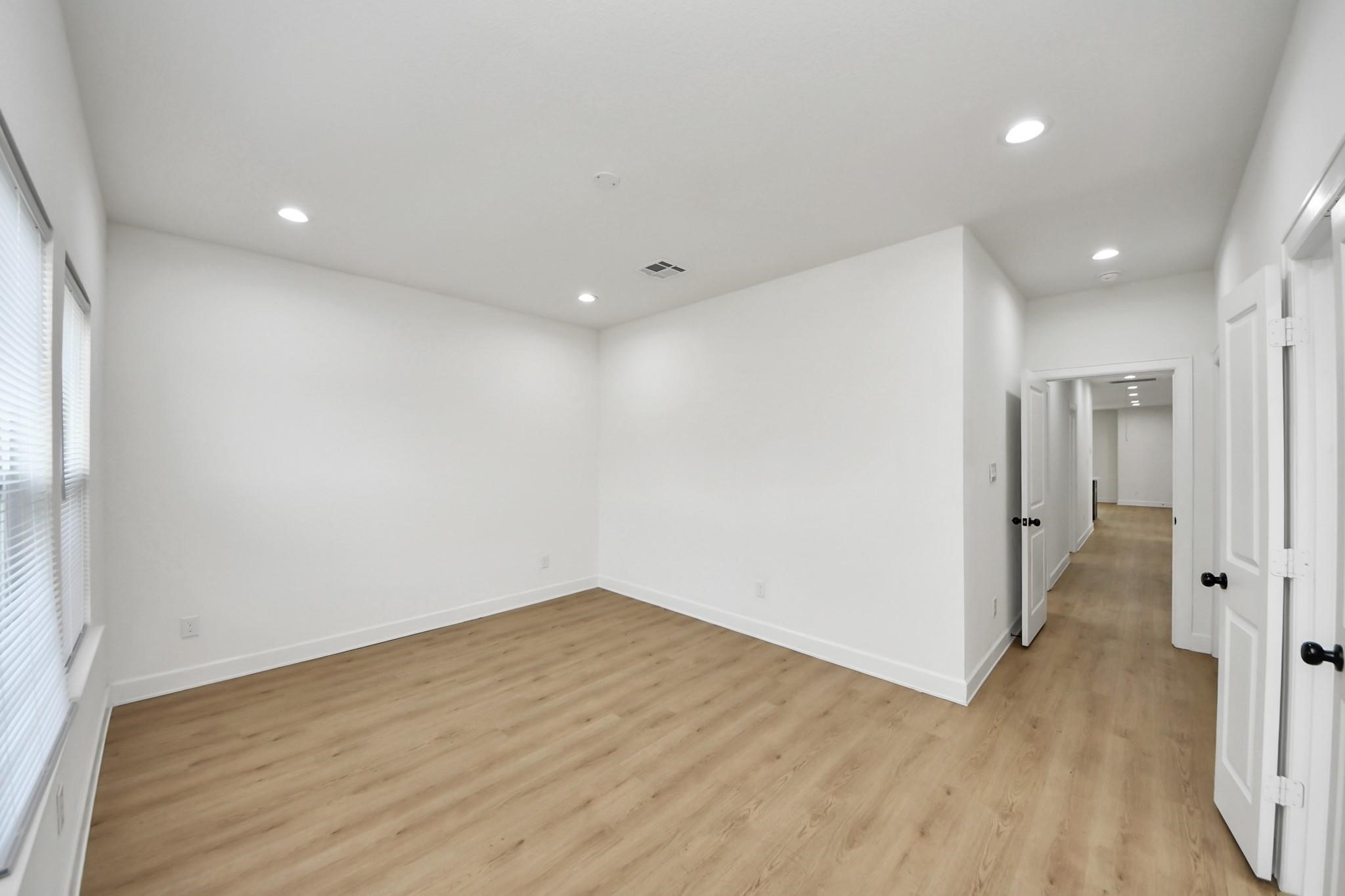 The spacious primary suite features recessed lighting, vinyl plank flooring, and a modern neutral palette. The spacious primary suite features recessed lighting, vinyl plank flooring, and a modern neutral palette.