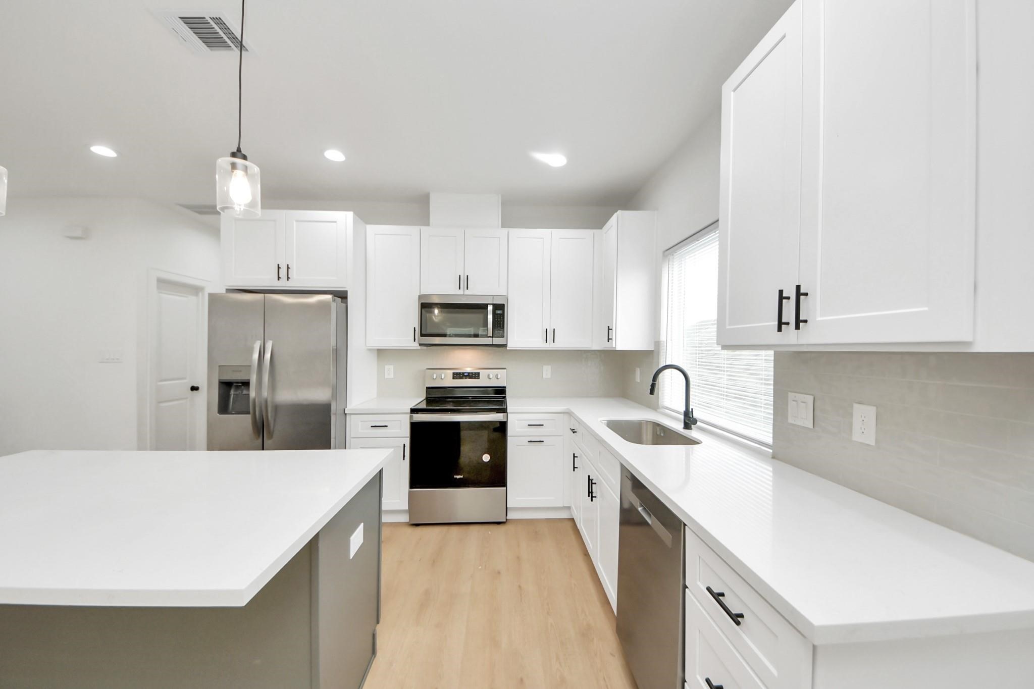 A large window brings natural light into the heart of the homes open-concept layout. A large window brings natural light into the heart of the homes open-concept layout.