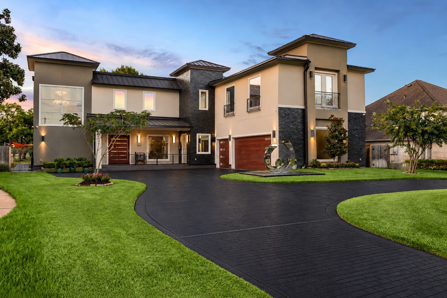 A distinctive composition of contemporary architectural lines, contrasting exterior finishes, expansive windows, and carefully positioned exterior lighting. The sweeping circular driveway provides an impressive approach to the residence and its attached three-car garage.
