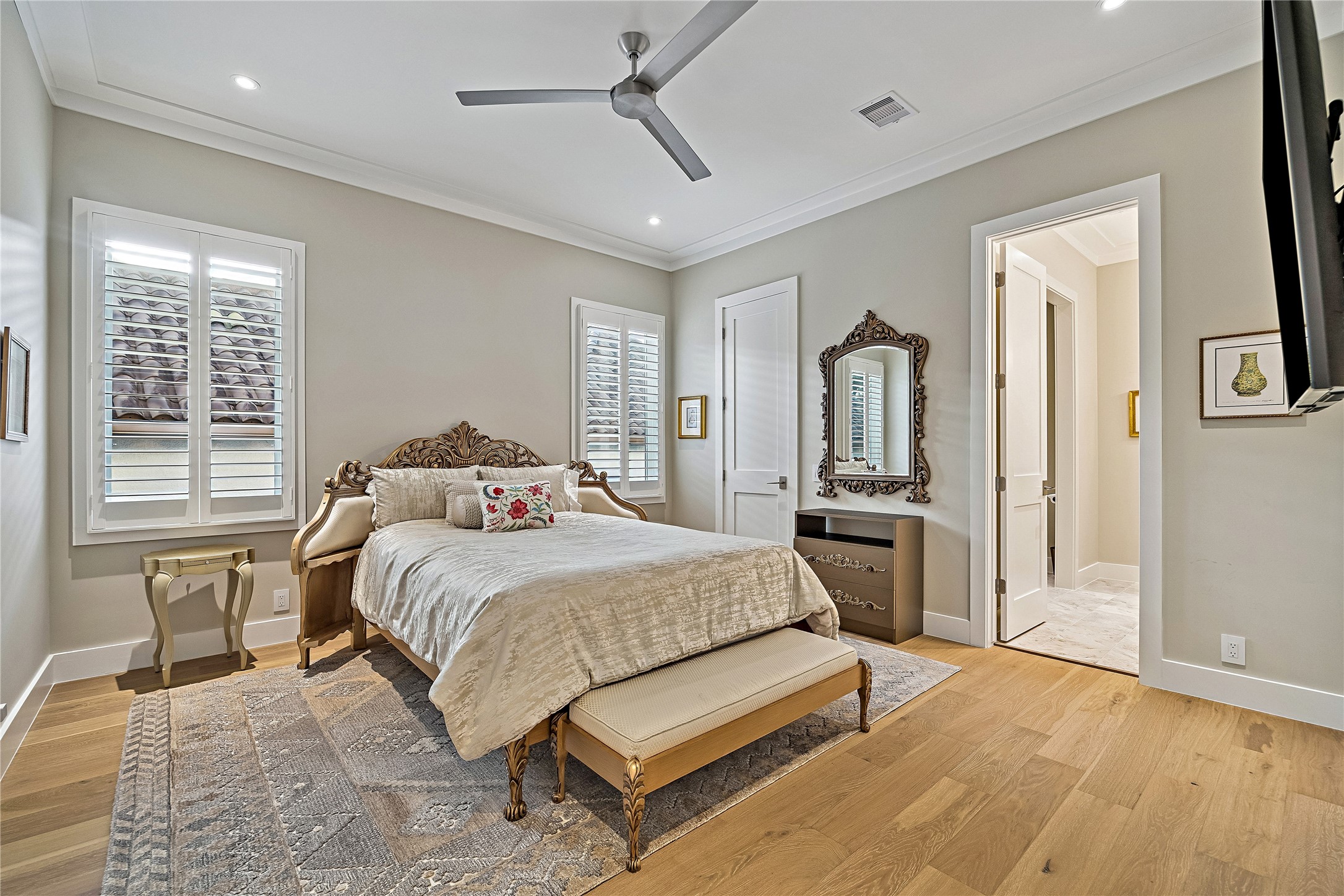 Generously proportioned upper-level bedroom featuring wood flooring, elegant neutral finishes, and abundant natural light. The spacious layout accommodates comfortable bedroom furnishings.