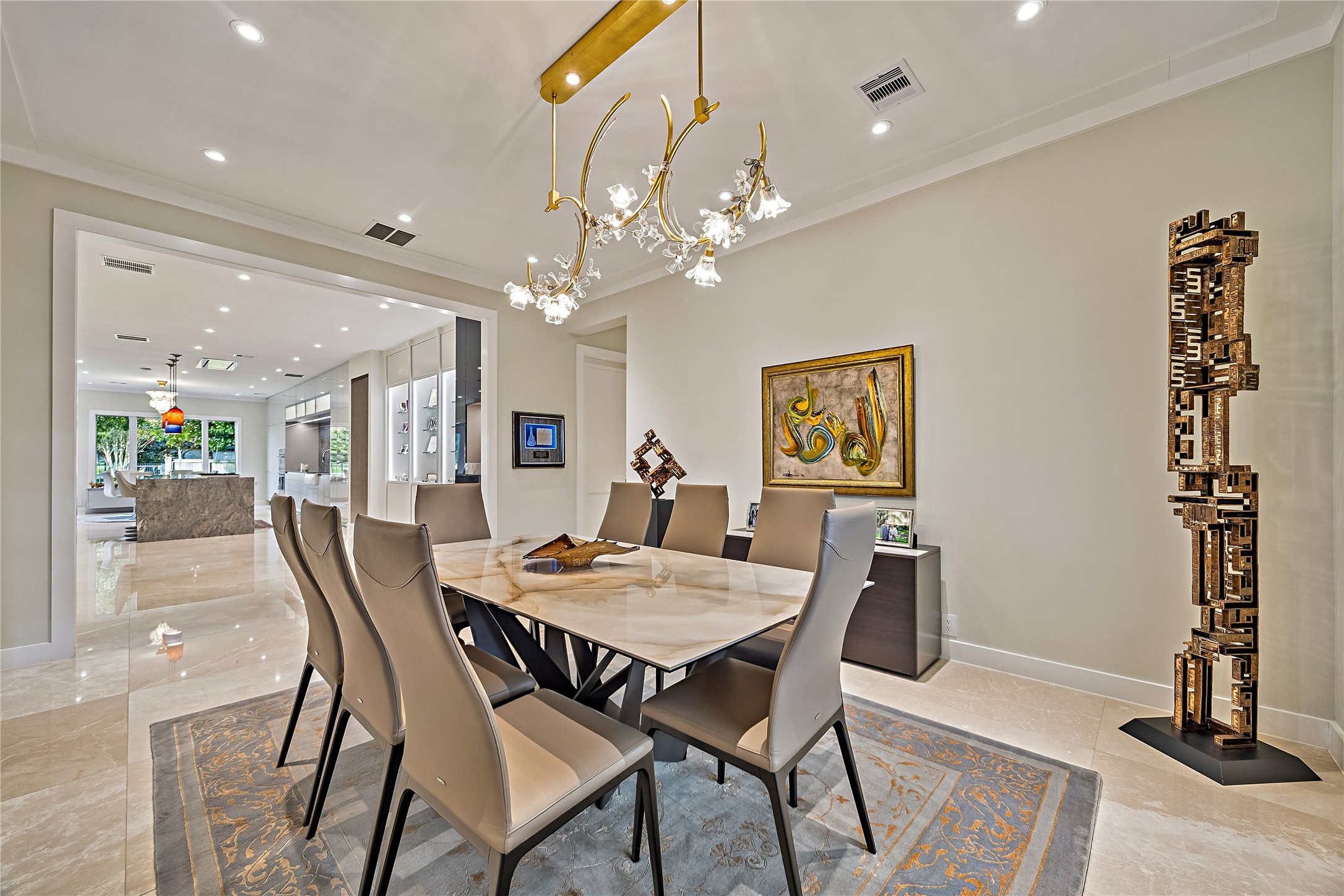 An elegant dining room featuring a sculptural chandelier, refined finishes, and generous seating accommodations. An ideal setting for formal dinners, special occasions, and entertaining.
