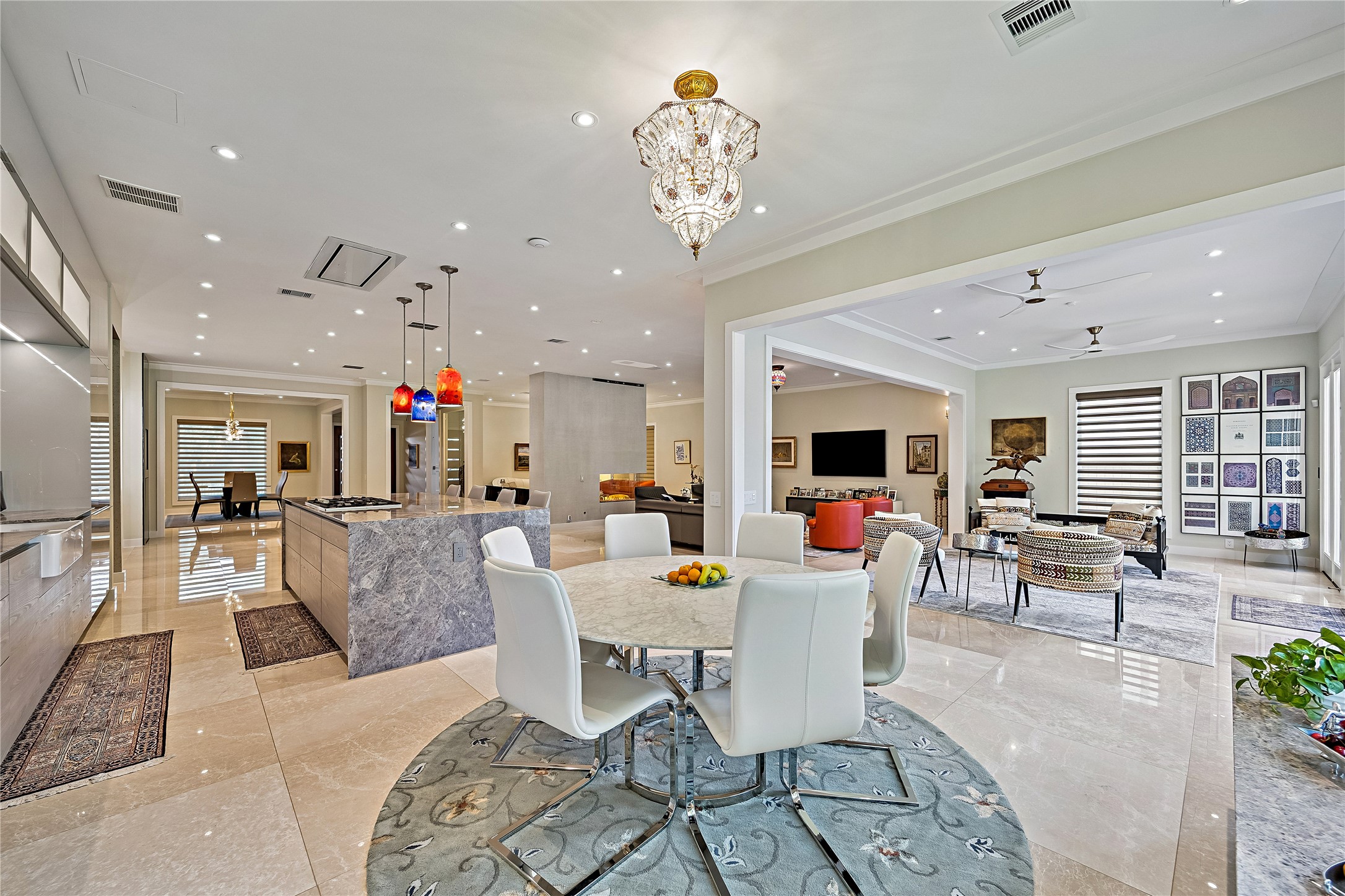 A sophisticated dining area surrounded by contemporary cabinetry and expansive kitchen surfaces. Statement lighting and the connected floor plan create an inviting environment for casual meals and gatherings.