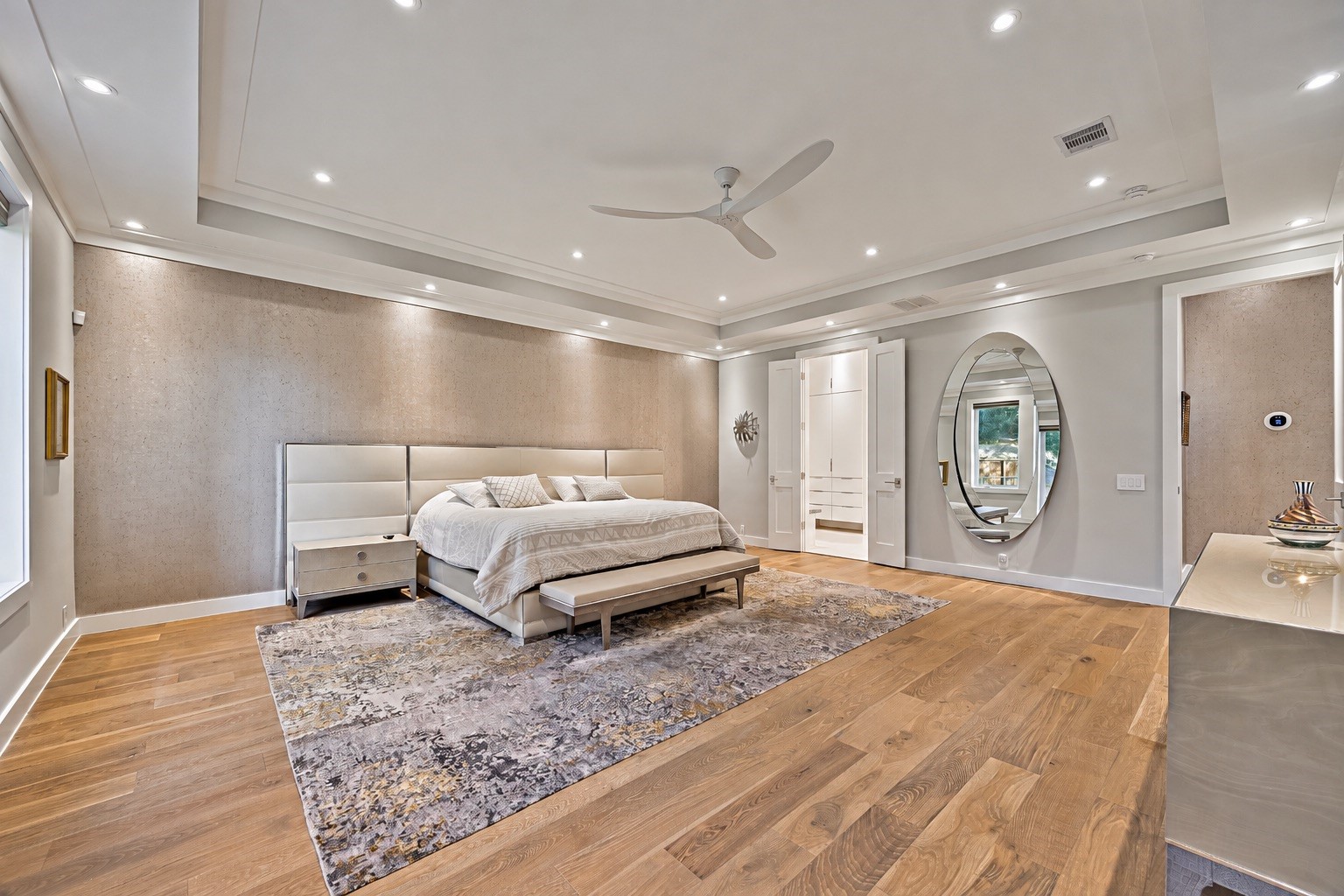 A second view of the spacious primary suite showcasing its generous proportions, elegant finishes, and thoughtfully arranged living space. The suite connects to a luxurious primary bathroom and custom walk-in closet.