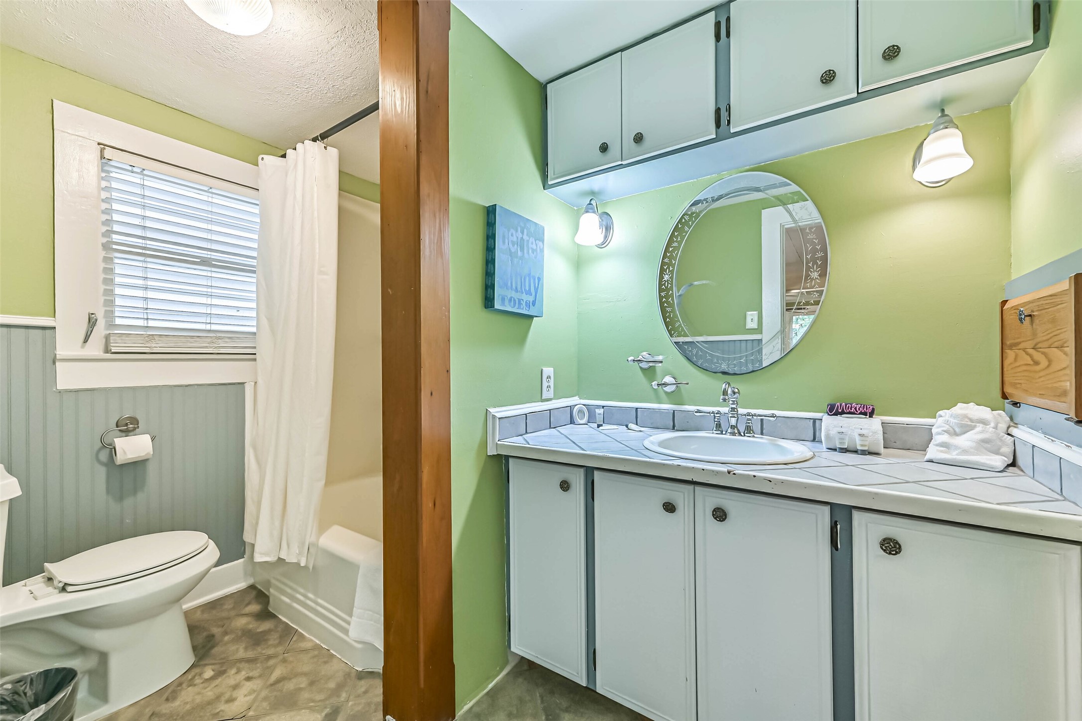 A refreshing bathroom with a vanity, mirror, and natural light, offering a comfortable space for daily routines.