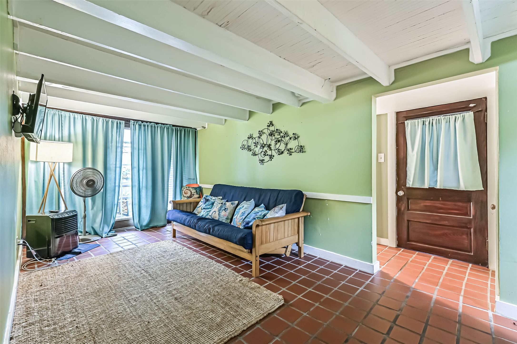 A cozy living area offers a welcoming place to unwind, with comfortable seating and warm tile flooring.