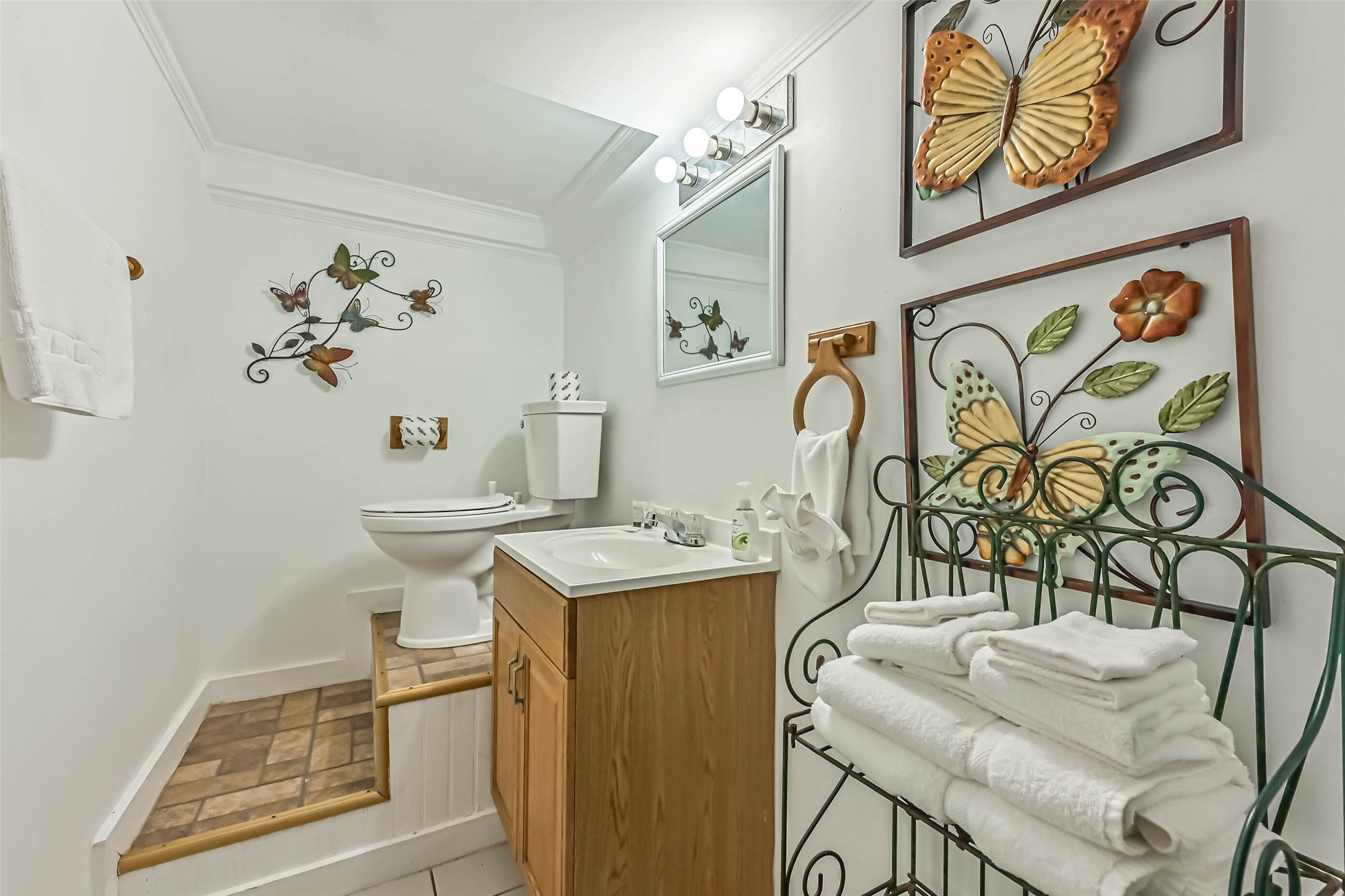 A charming bathroom featuring wood cabinetry and decorative accents, adding warmth and personality to the space.