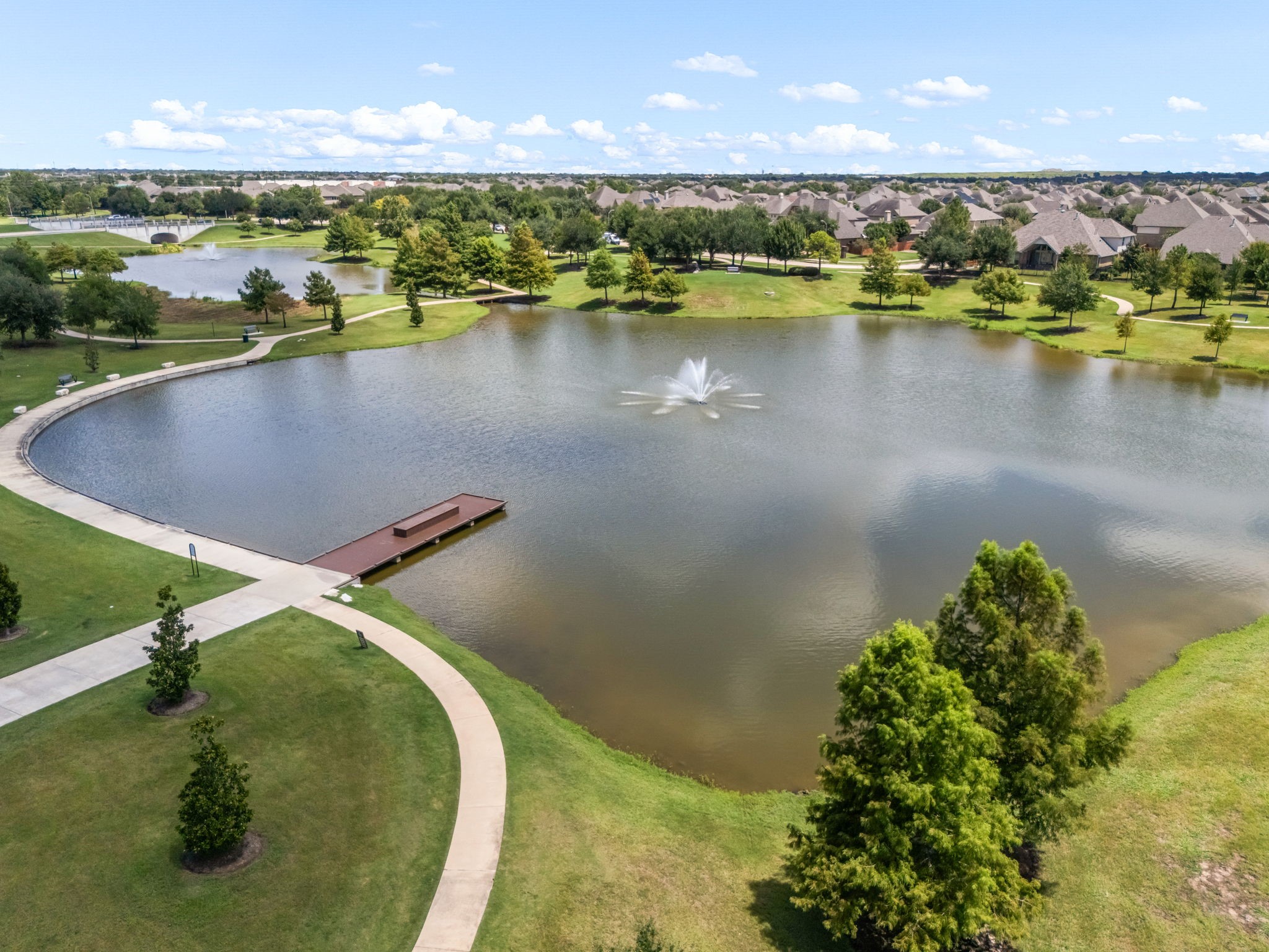 Scenic water features and landscaped surroundings add to Alianas thoughtfully planned setting, creating attractive views throughout the community. The lakefront setting shown here highlights the neighborhoods emphasis on expansive outdoor spaces and a connected community design.