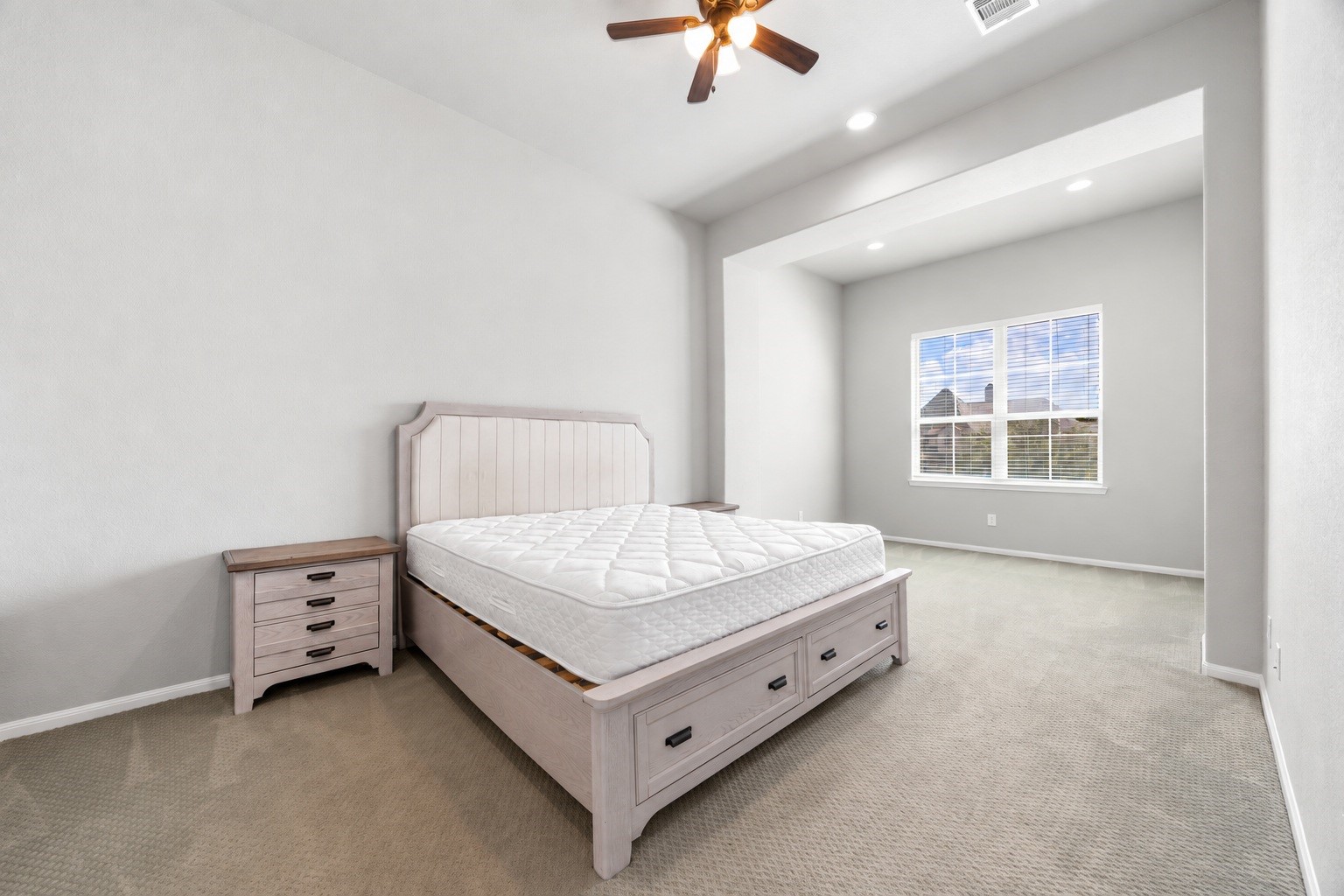 The home's second primary suite offers an expansive footprint with a large windowed sitting area, giving this upstairs retreat flexibility as a private suite or secondary living space.