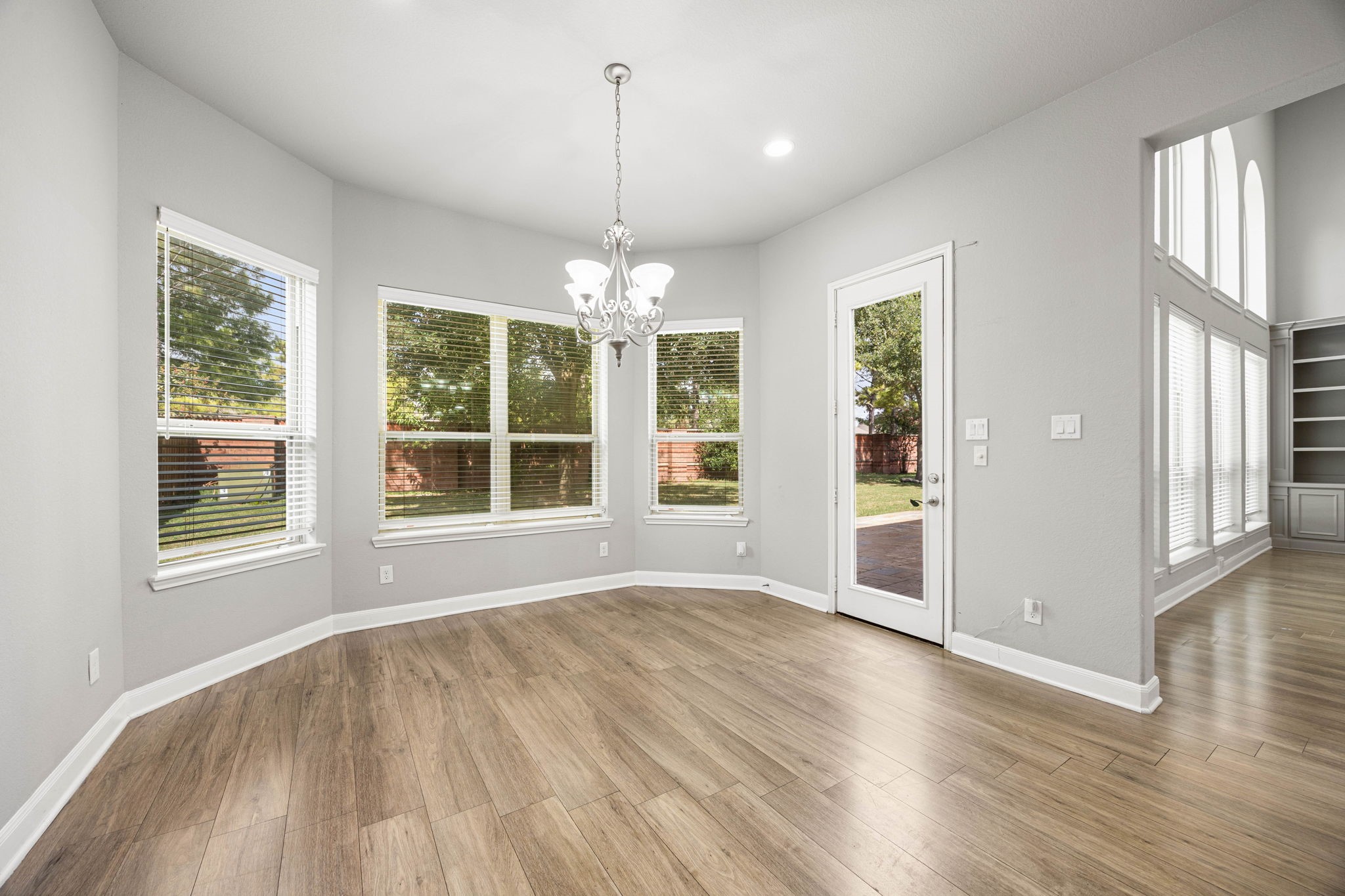 A sunny breakfast nook wraps in windows overlooking the backyard, with a door leading directly out to the patio  an easy, everyday spot for morning coffee.